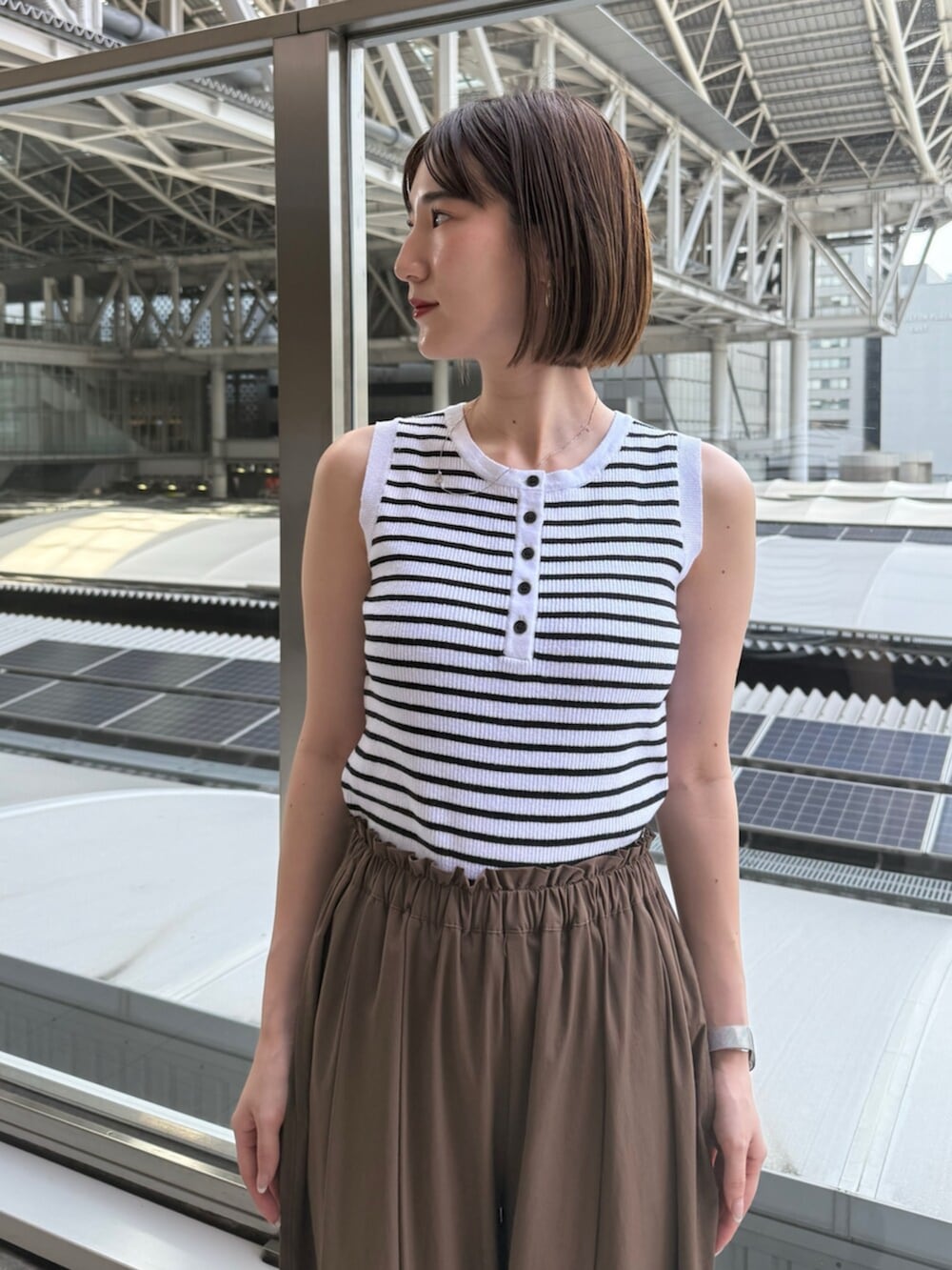 ブラック系のサンダル、ホワイト系のニット/セーター、ブラウン系のその他パンツを着用したレディースの夏コーディネートの5枚目の写真