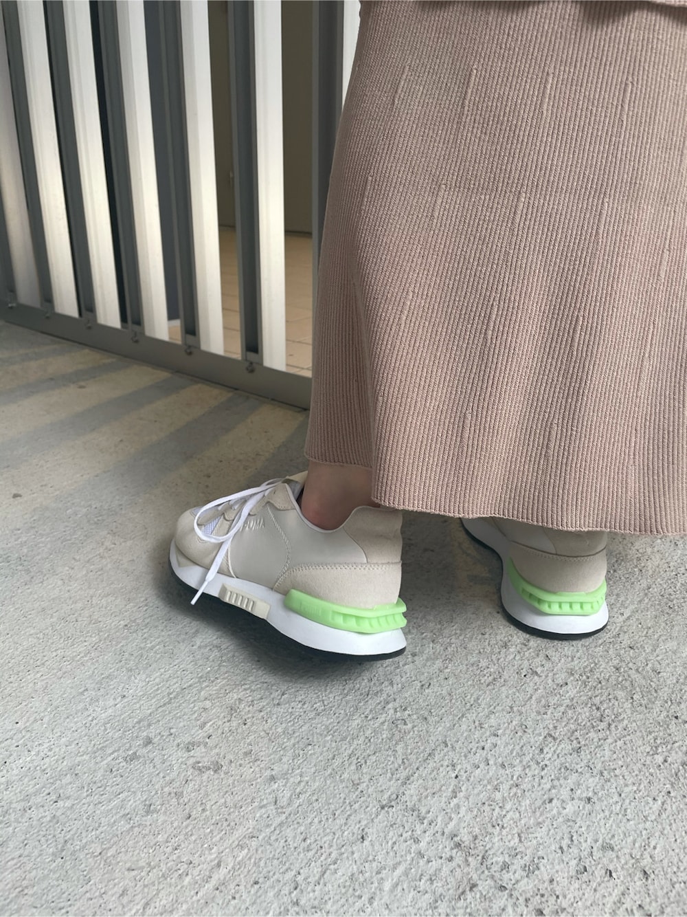ホワイト系のスニーカー、ベージュ系のスカート、ホワイト系のTシャツ/カットソーを着用したレディースの春コーディネートの7枚目の写真