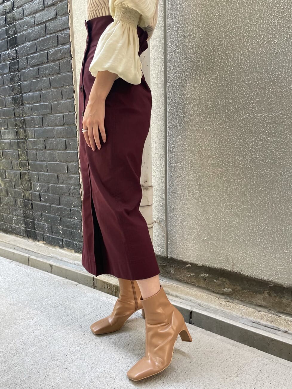 ベージュ系のニット/セーター、レッド系のスカート、ベージュ系のその他シューズを着用したレディースの夏コーディネートの5枚目の写真