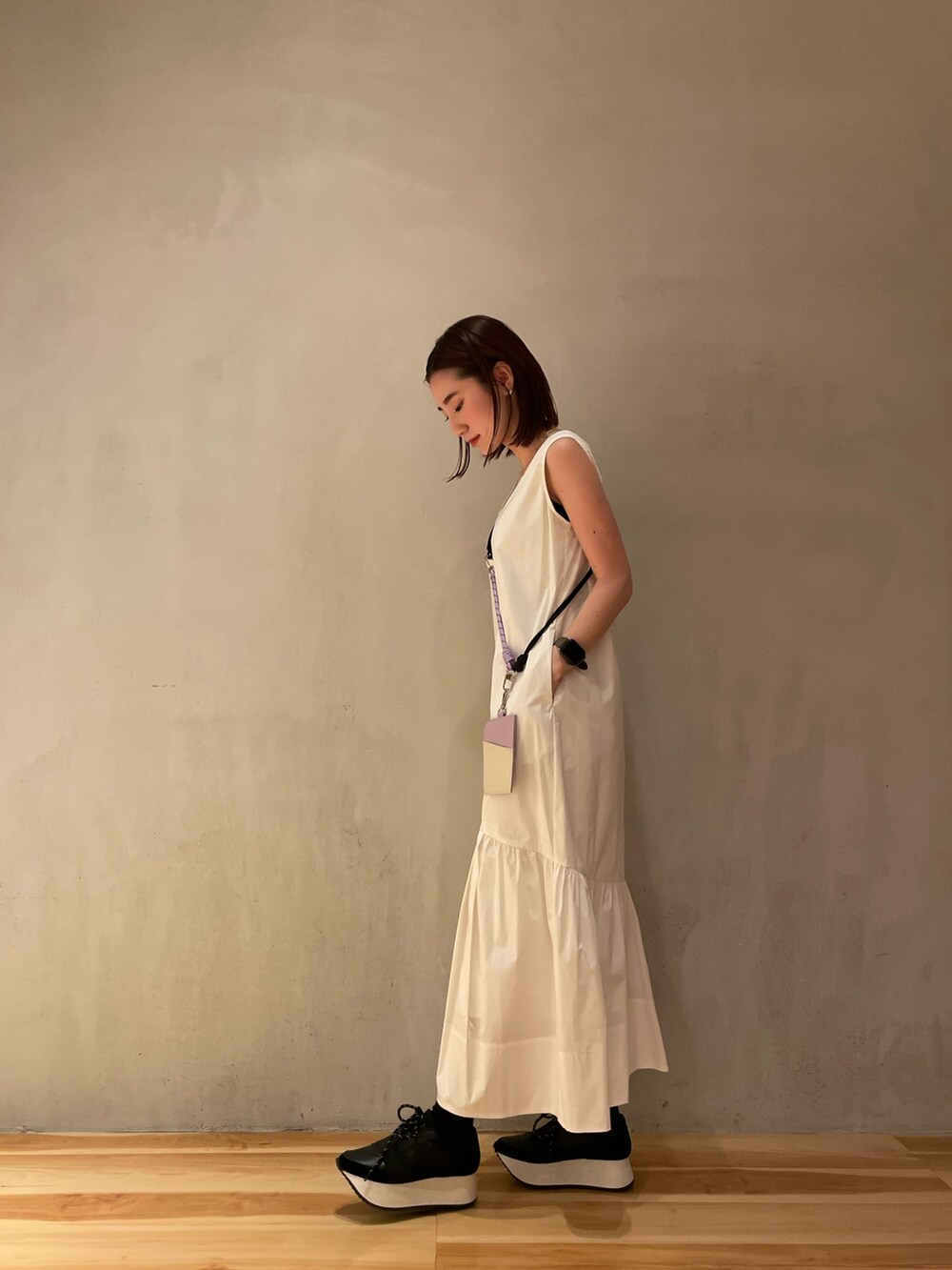 ホワイト系のワンピース、ブラック系のスニーカー、パープル系のスマホケース/カバーを着用したレディースの冬コーディネートの4枚目の写真