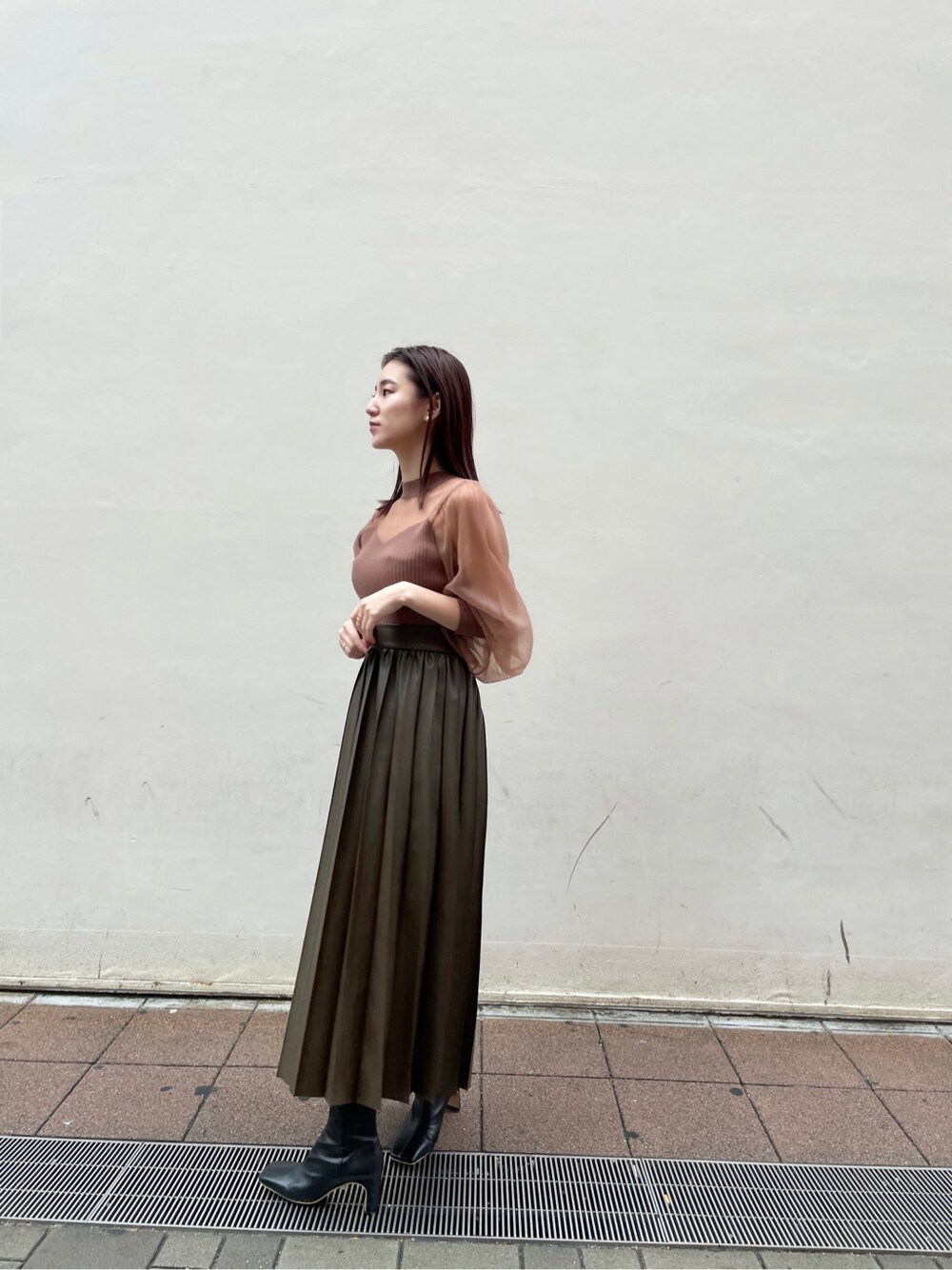 ブラウン系のスカート、ホワイト系のムートンコート、ベージュ系のニット/セーターを着用したレディースの冬コーディネートの3枚目の写真