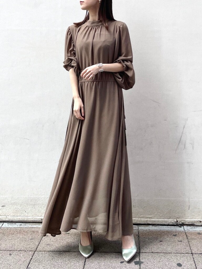 グリーン系のパンプス、ベージュ系のワンピースを着用したレディースの冬コーディネートの4枚目の写真