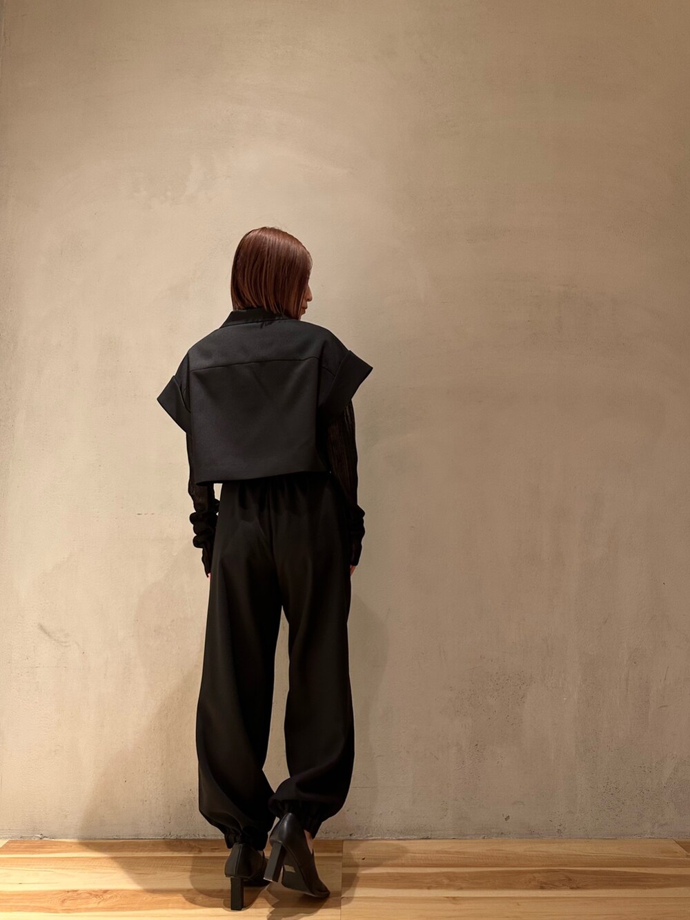 ブラック系のスラックス、ブラック系のニット/セーター、ブラック系のテーラードジャケットを着用したレディースの春コーディネートの7枚目の写真