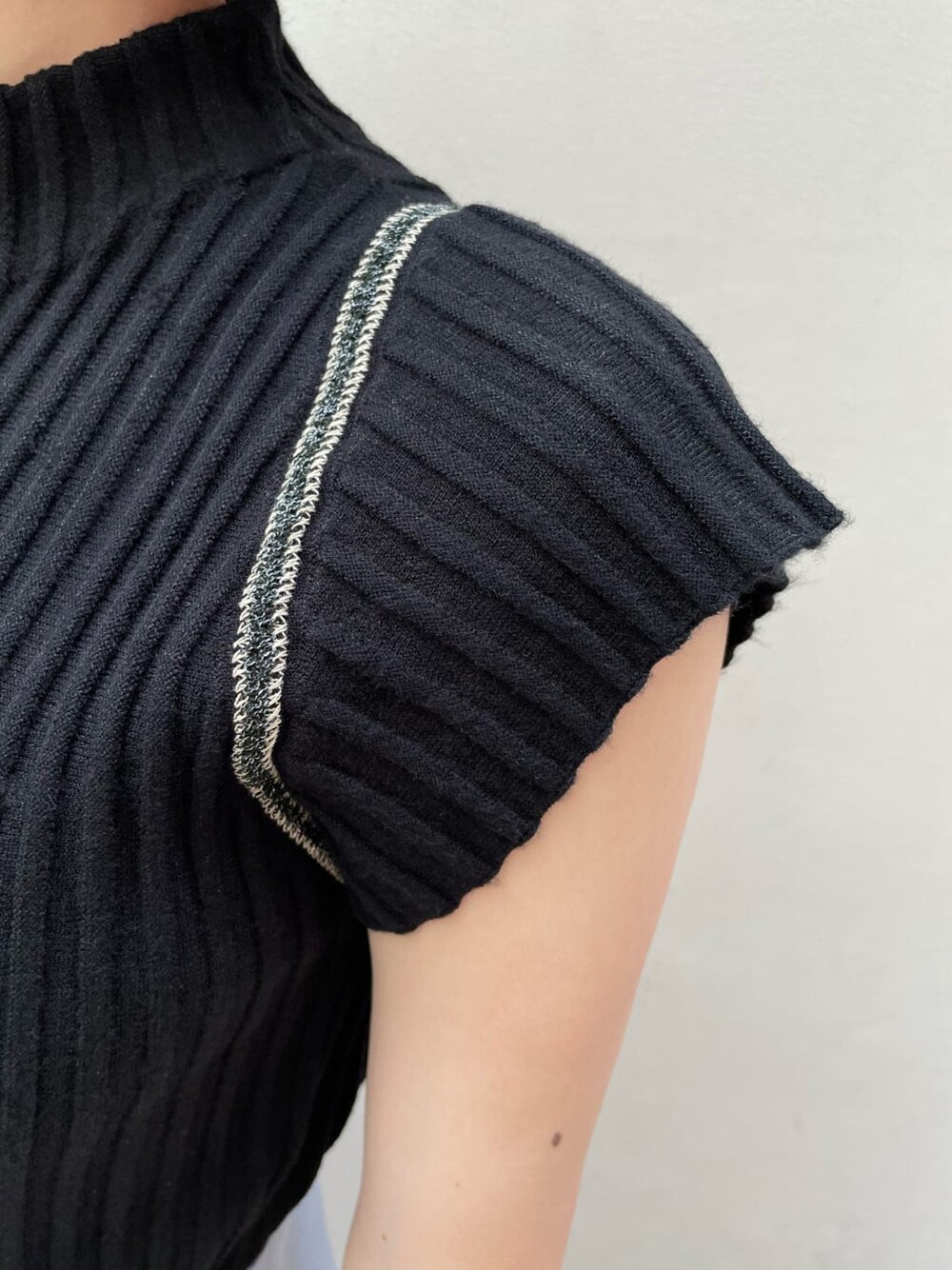 ブルー系のスカート、ブラック系のニット/セーターを着用したレディースの夏コーディネートの5枚目の写真