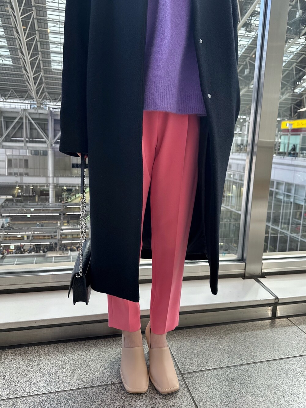 ブラック系のノーカラーコート、ブラック系のショルダーバッグ、ベージュ系のパンプスを着用したレディースの秋コーディネートの5枚目の写真