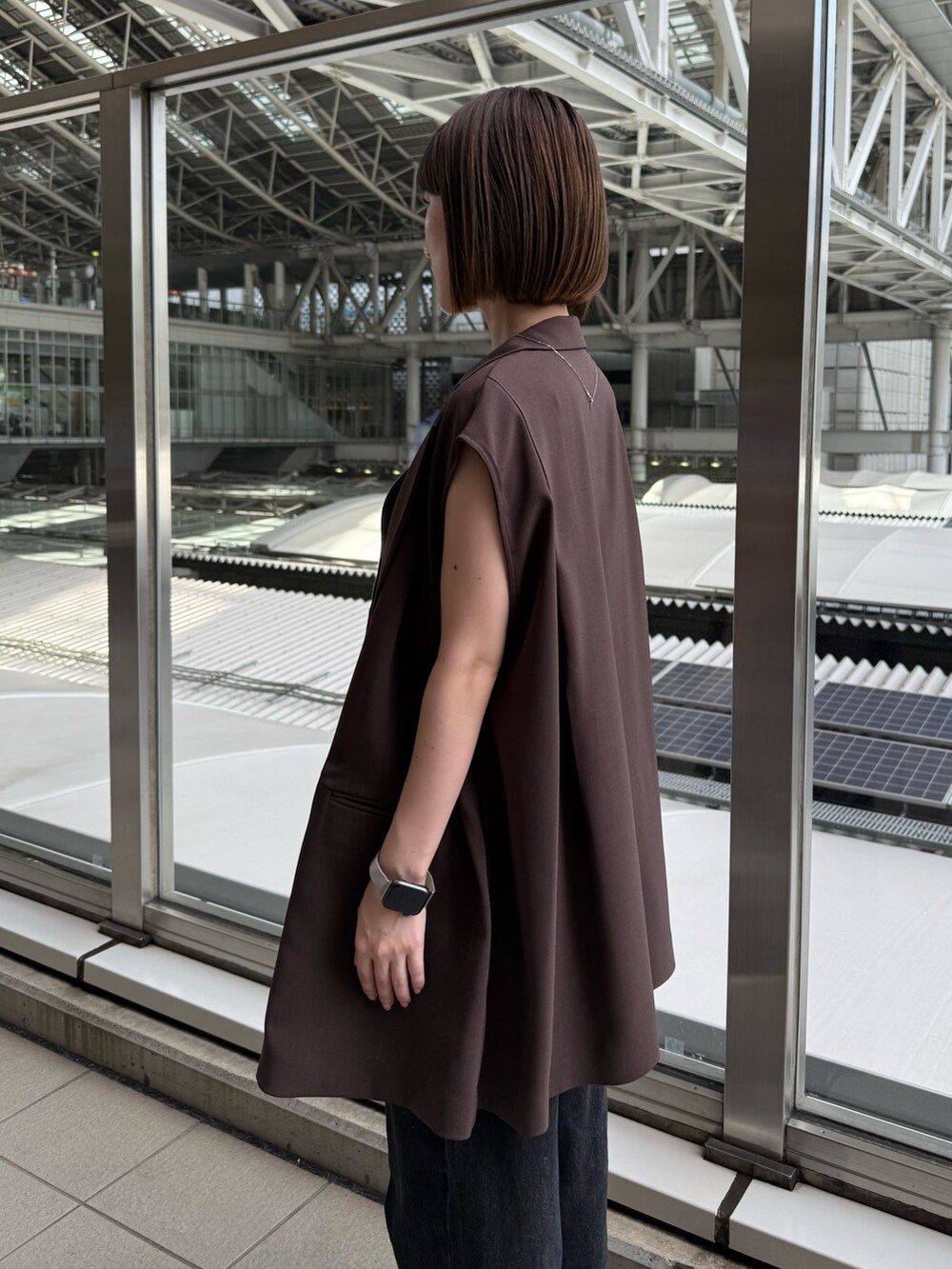ブラウン系のテーラードジャケット、ブラック系のデニムパンツ、ブラウン系のショルダーバッグを着用したレディースの夏コーディネートの4枚目の写真