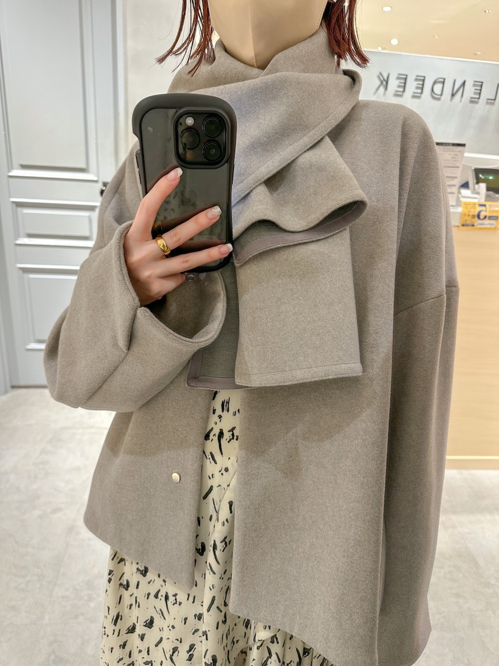 グレー系のステンカラーコート、その他のワンピースを着用したレディースの冬コーディネートの6枚目の写真