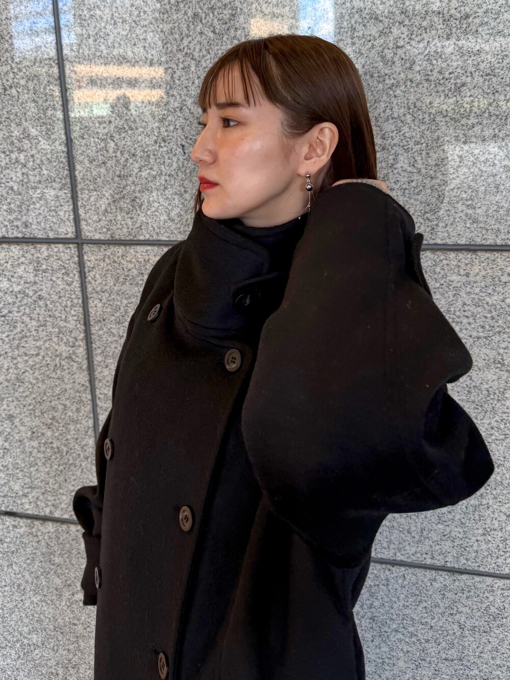 ブラック系のその他アウター、シルバー系のボストンバッグ、ブラック系のブーツを着用したレディースの冬コーディネートの5枚目の写真