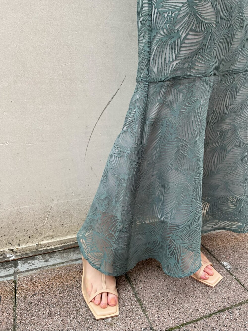 ブルー系のスカート、ベージュ系のサンダル、ブラック系のニット/セーターを着用したレディースの夏コーディネートの8枚目の写真