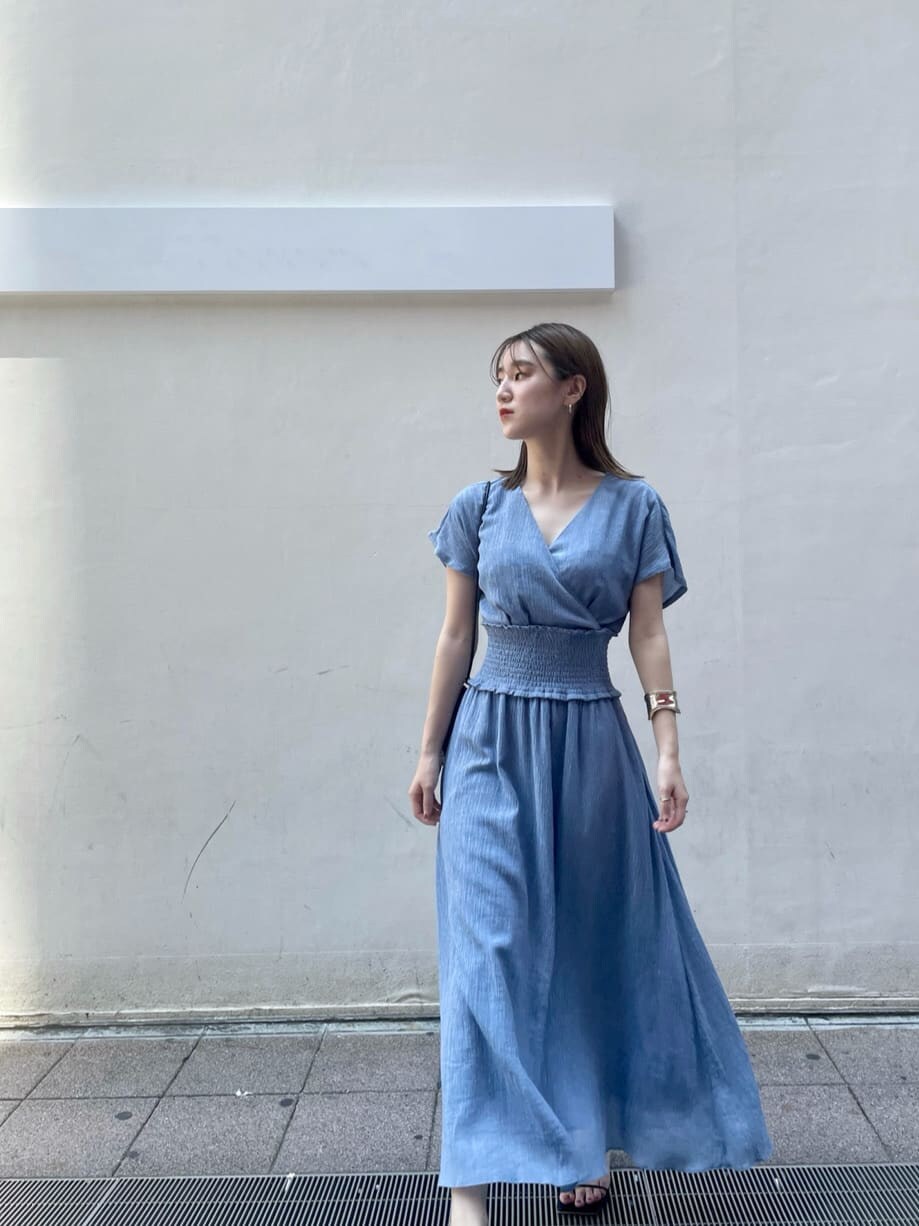 ブラック系のハンドバッグ、ブラック系のサンダル、ブルー系のワンピースを着用したレディースの夏コーディネートの8枚目の写真