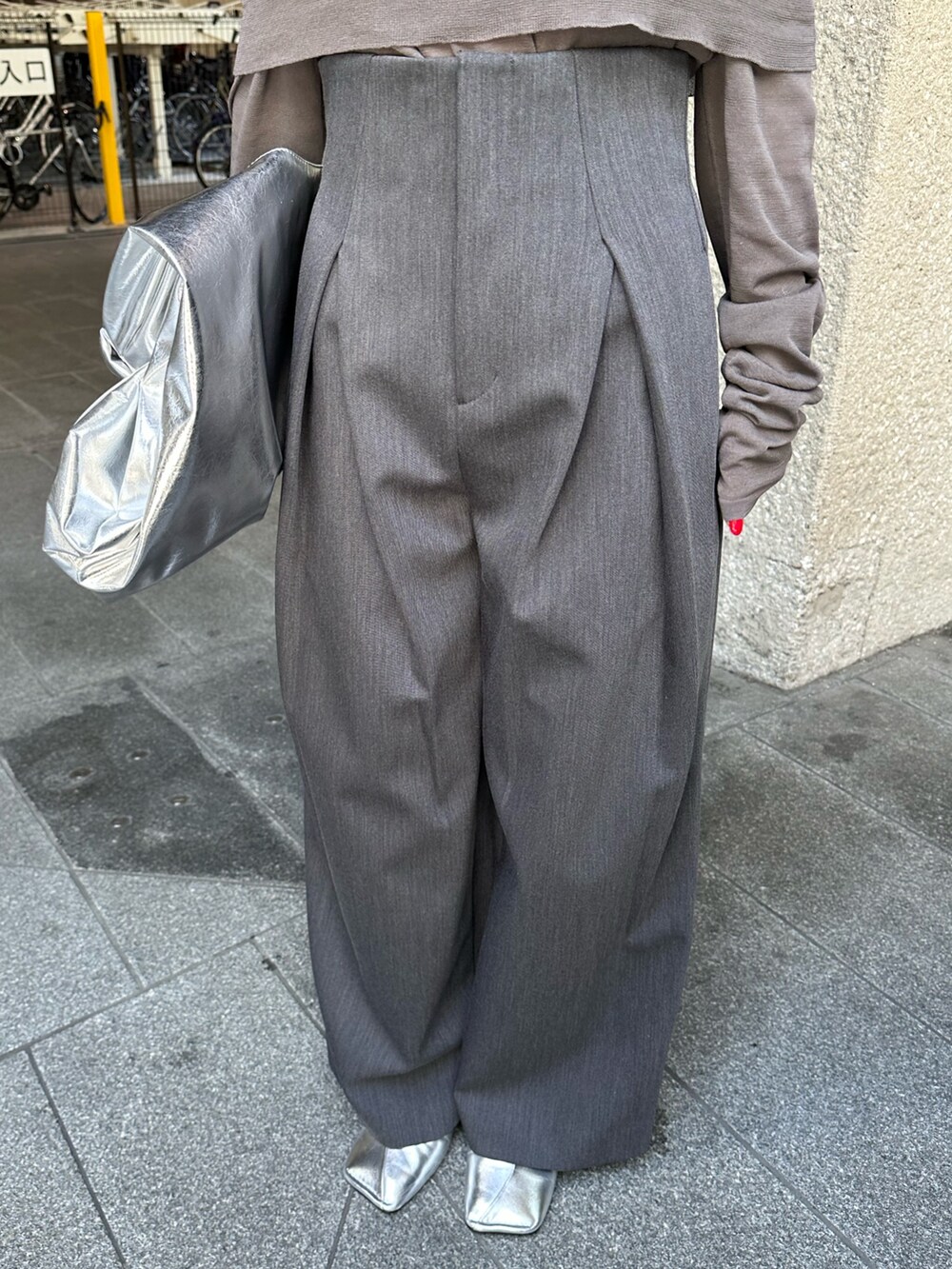 グレー系のニット/セーター、グレー系のその他パンツ、シルバー系のトートバッグを着用したレディースの夏コーディネートの7枚目の写真