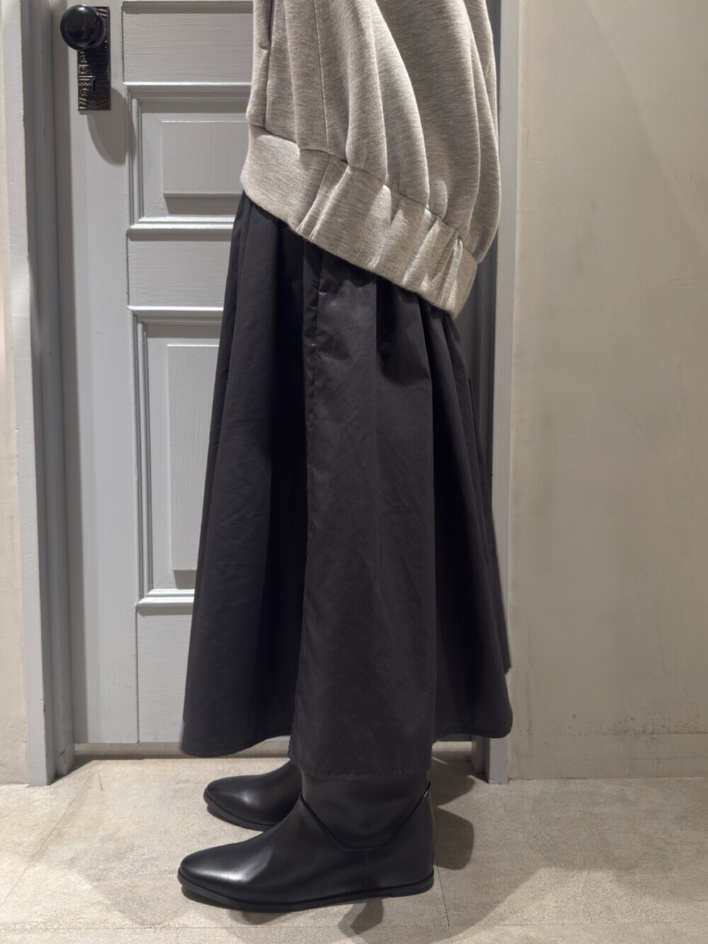 ブラック系のブーツ、グレー系のワンピースを着用したレディースの秋コーディネートの8枚目の写真