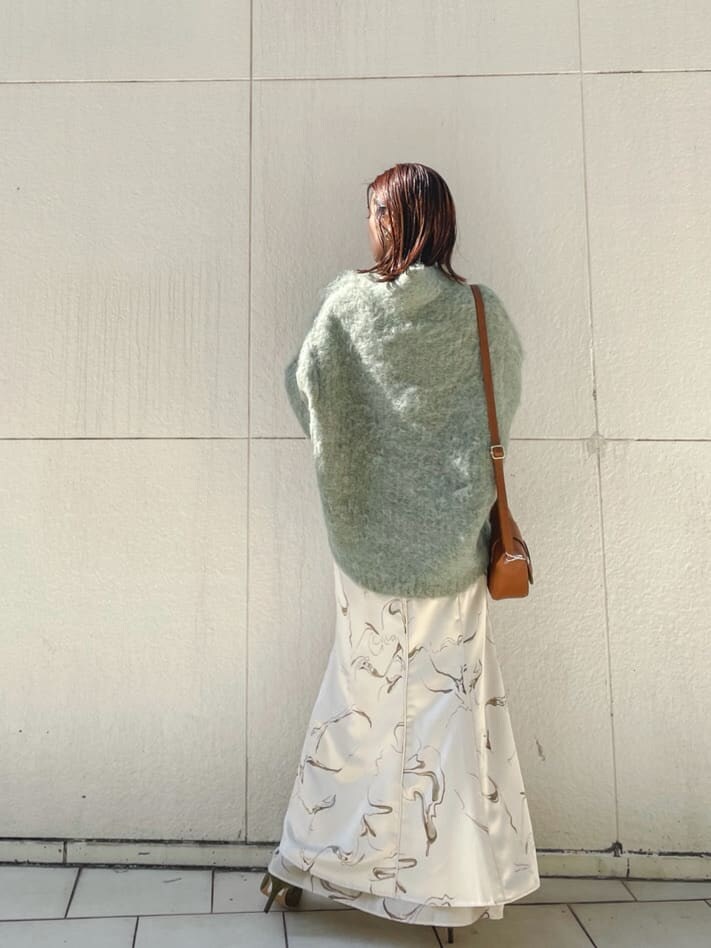 ベージュ系のブーツ、ブラウン系のショルダーバッグ、ホワイト系のスカートを着用したレディースの秋コーディネートの6枚目の写真