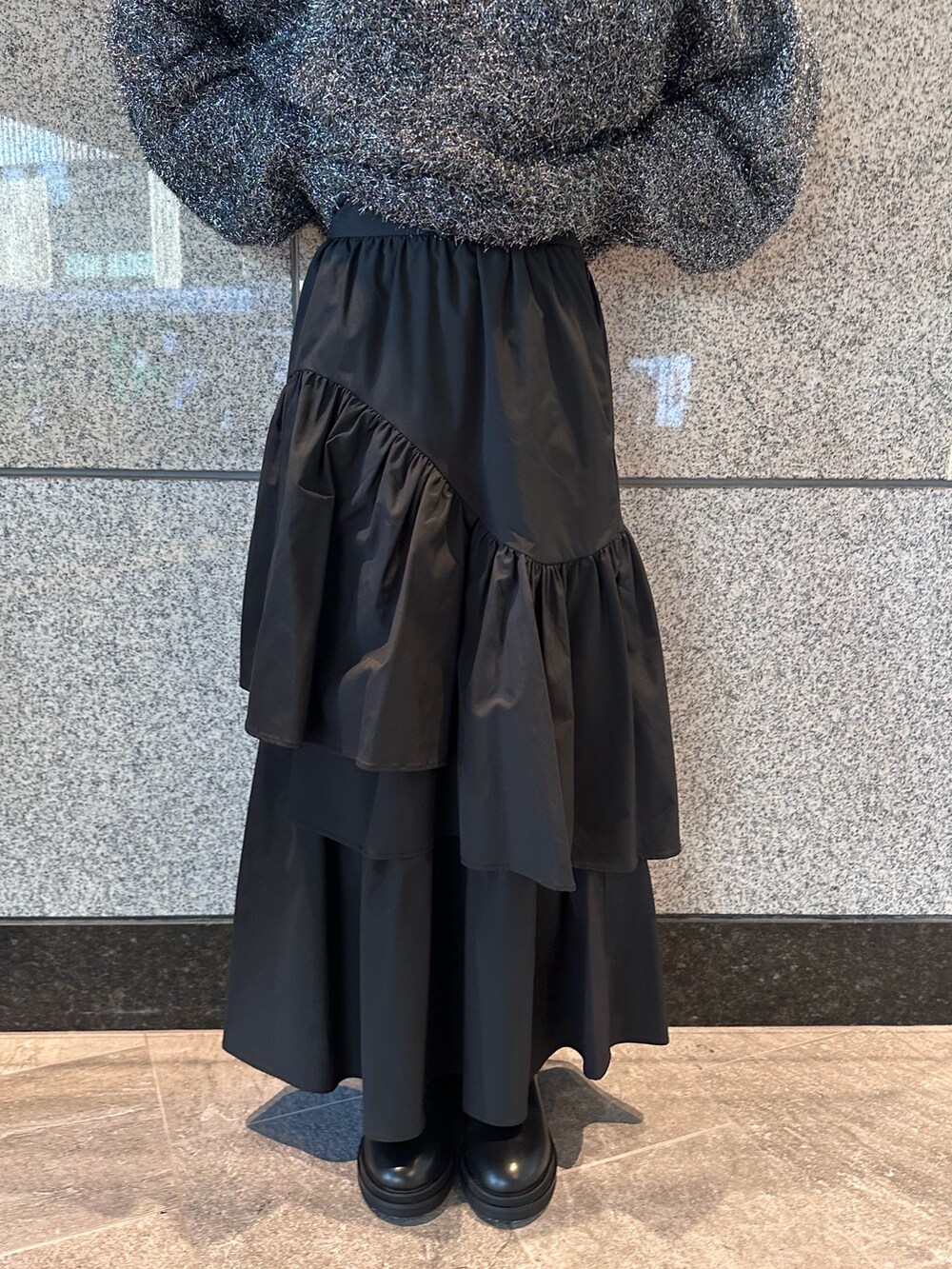 ブラック系のニット/セーター、ブラック系のスカートを着用したレディースの秋コーディネートの6枚目の写真