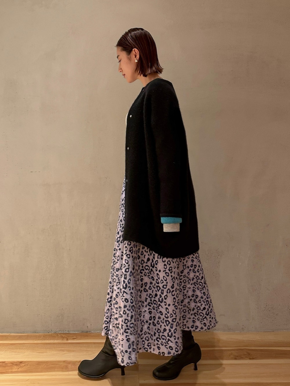 ブラック系のカーディガン/ボレロ、グレー系のTシャツ/カットソー、パープル系のスカートを着用したレディースの冬コーディネートの3枚目の写真