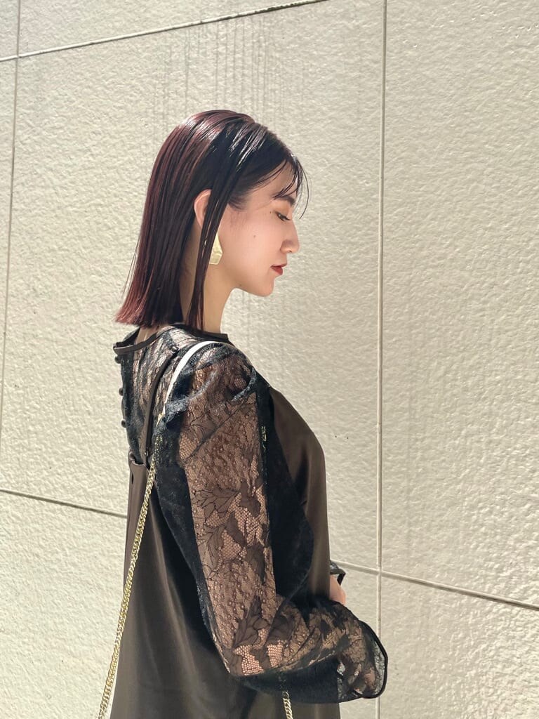 ブラック系のドレス、ベージュ系のパンプス、ベージュ系のクラッチバッグを着用したレディースの秋コーディネートの2枚目の写真