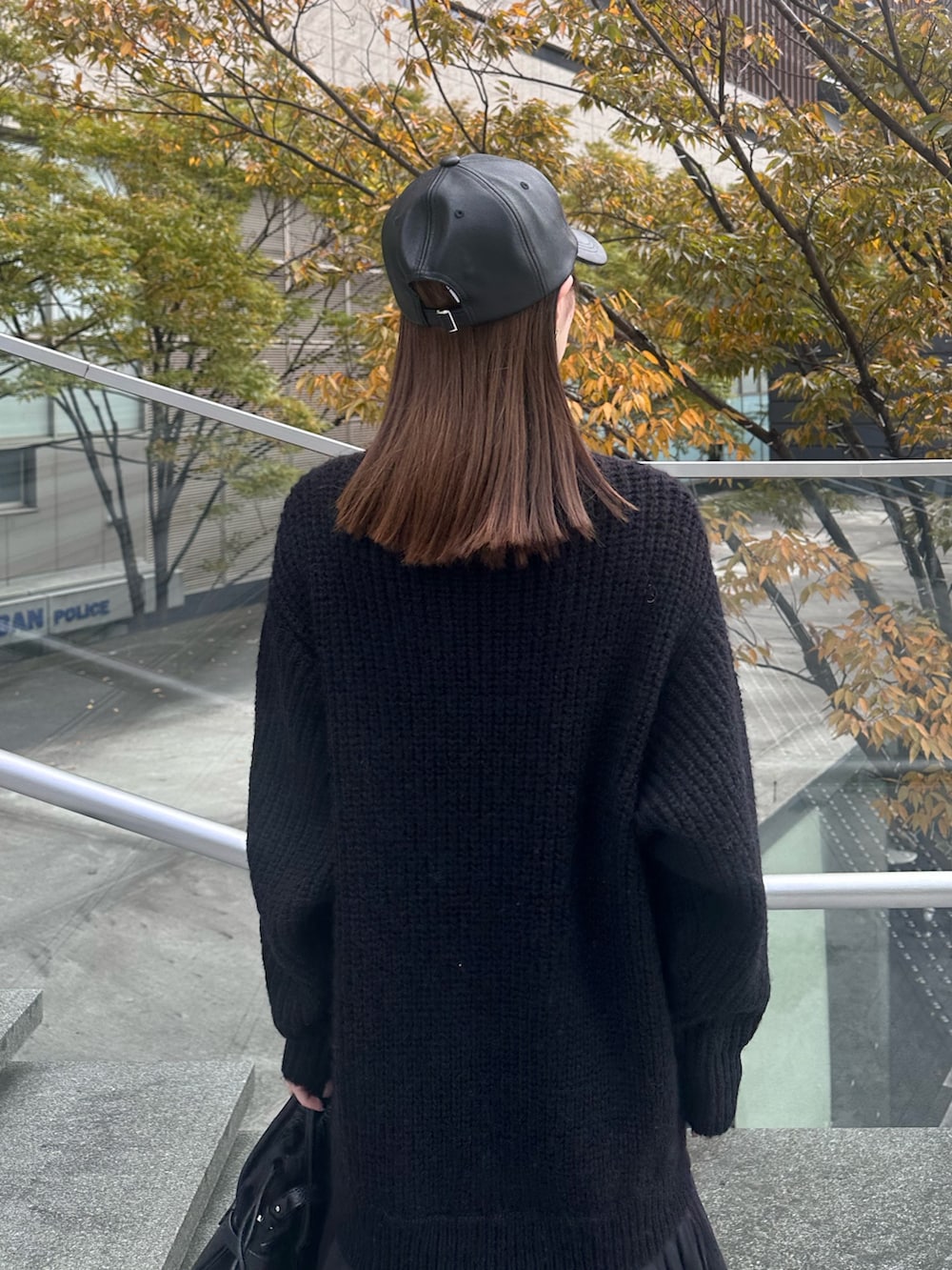 ブラック系のワンピース、ブラック系のショルダーバッグ、ブラック系のキャップを着用したレディースの秋コーディネートの7枚目の写真