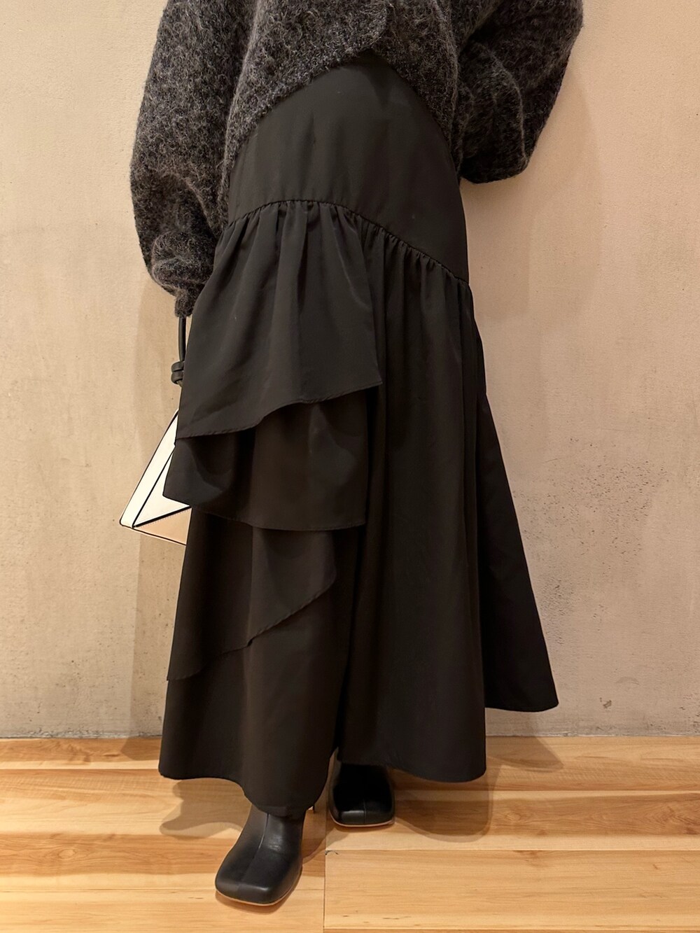 グレー系のカーディガン/ボレロ、ブラック系のスカート、ブラック系のブーツを着用したレディースの夏コーディネートの5枚目の写真