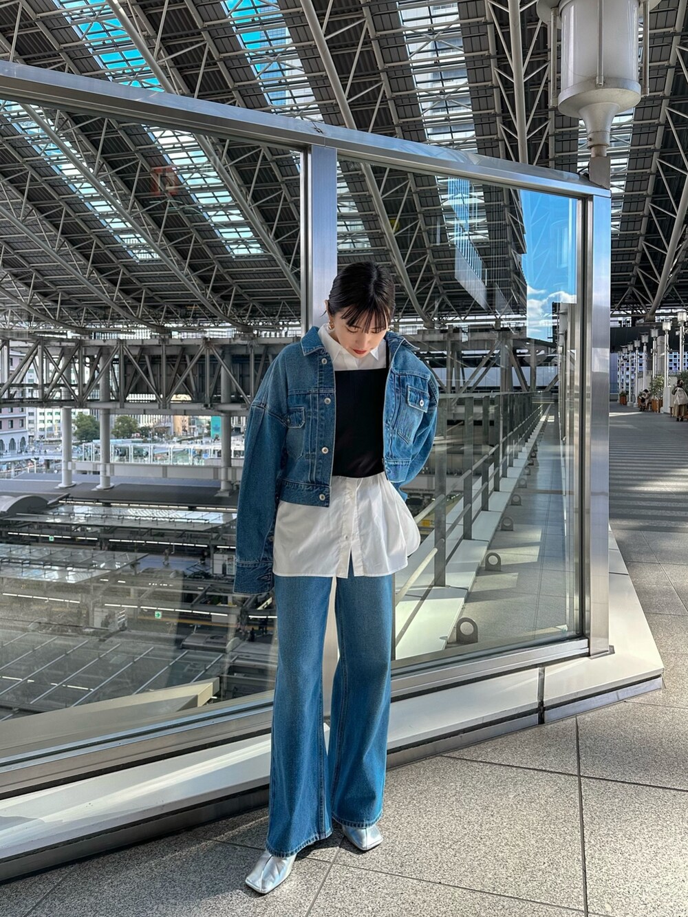 ブルー系のデニムジャケット、ブルー系のデニムパンツ、シルバー系のパンプスを着用したレディースの冬コーディネートの3枚目の写真