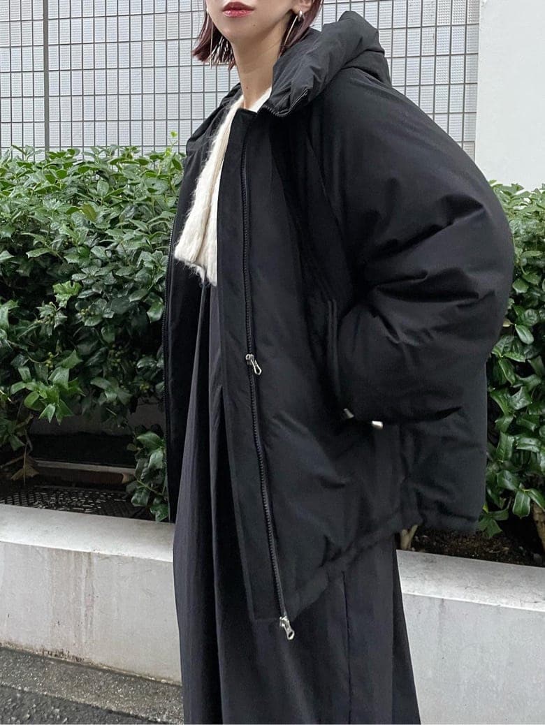 ブラック系のダウンジャケット/コート、ブラウン系のブーツ、ホワイト系のワンピースを着用したレディースの秋コーディネートの5枚目の写真