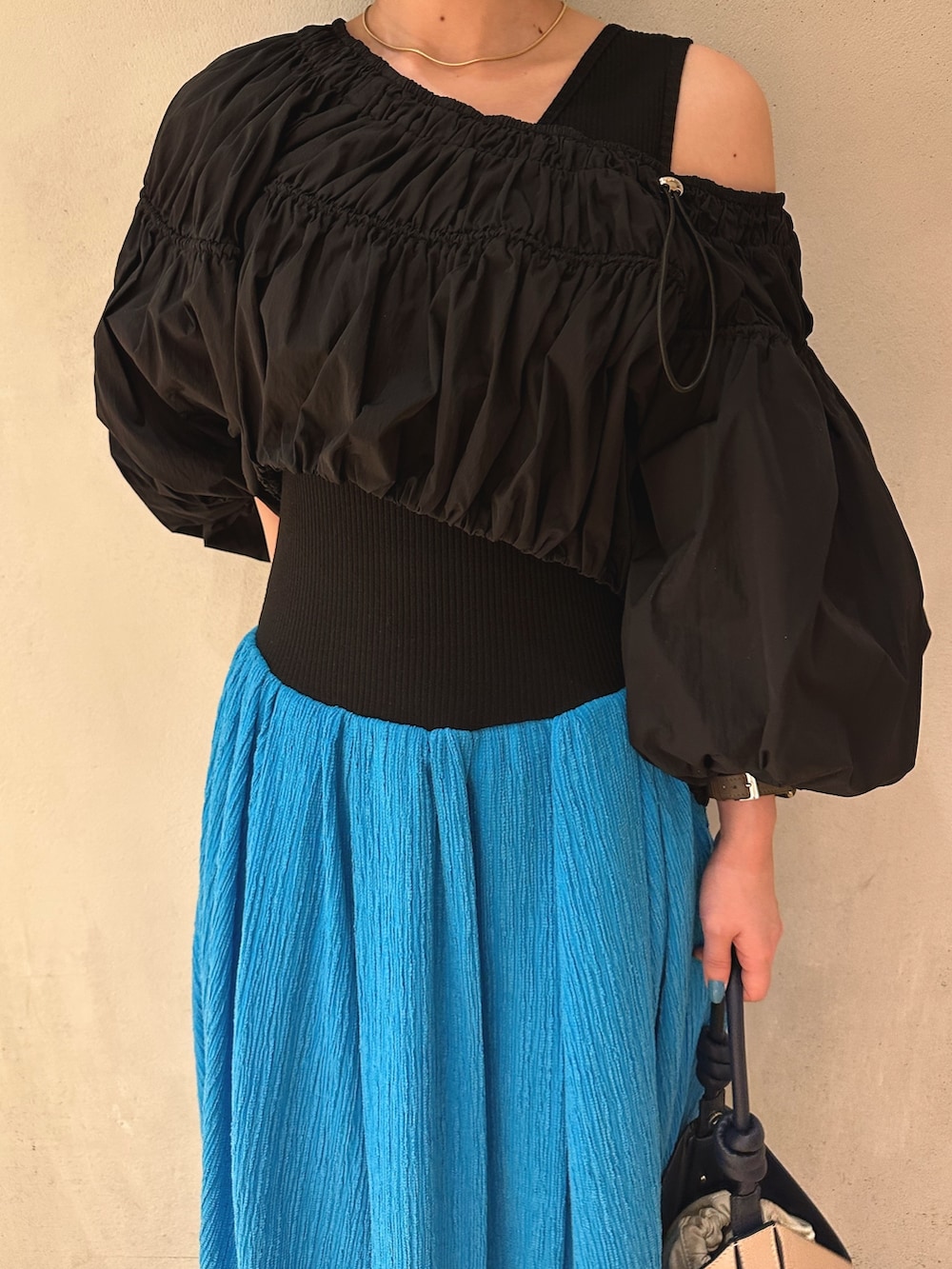 ベージュ系のハンドバッグ、ブルー系のワンピース、ホワイト系のスニーカーを着用したレディースの冬コーディネートの5枚目の写真