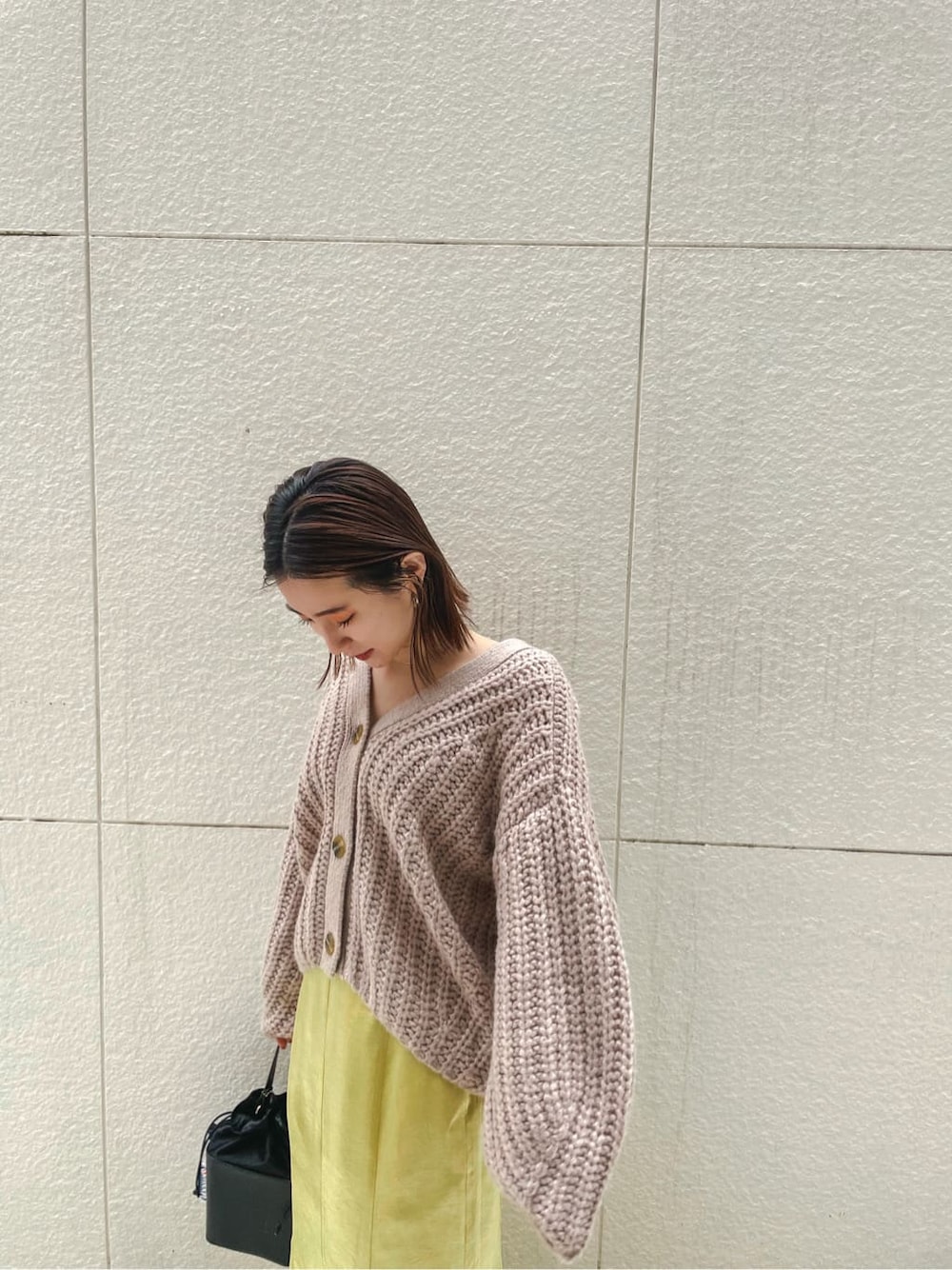 ブラック系のその他シューズ、ベージュ系のカーディガン/ボレロ、イエロー系のスカートを着用したレディースの冬コーディネートの5枚目の写真