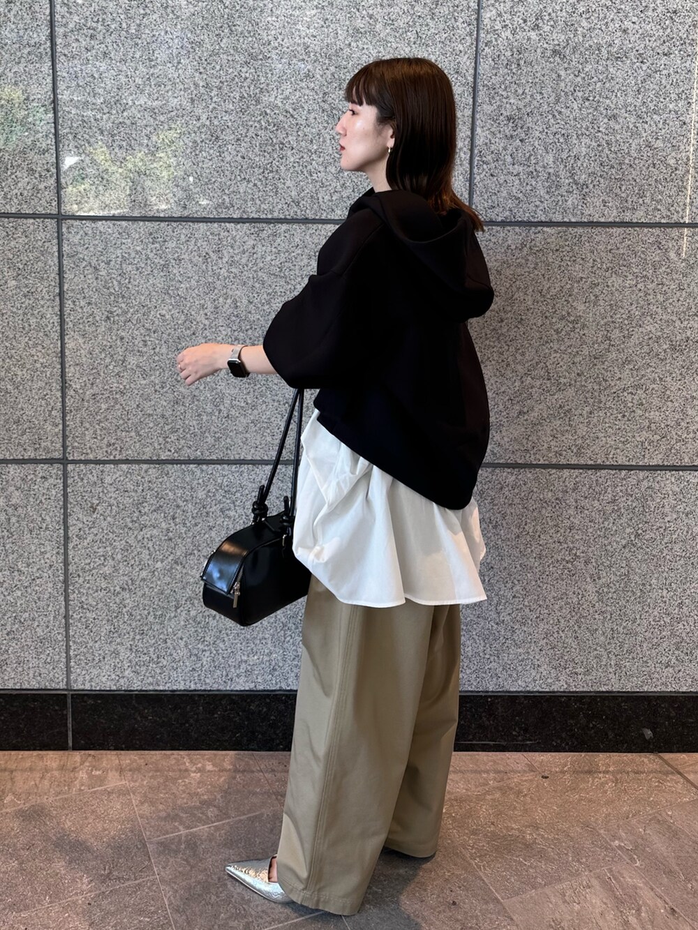 ベージュ系のその他パンツ、ブラック系のボストンバッグ、ブラック系のパーカーを着用したレディースの秋コーディネートの5枚目の写真