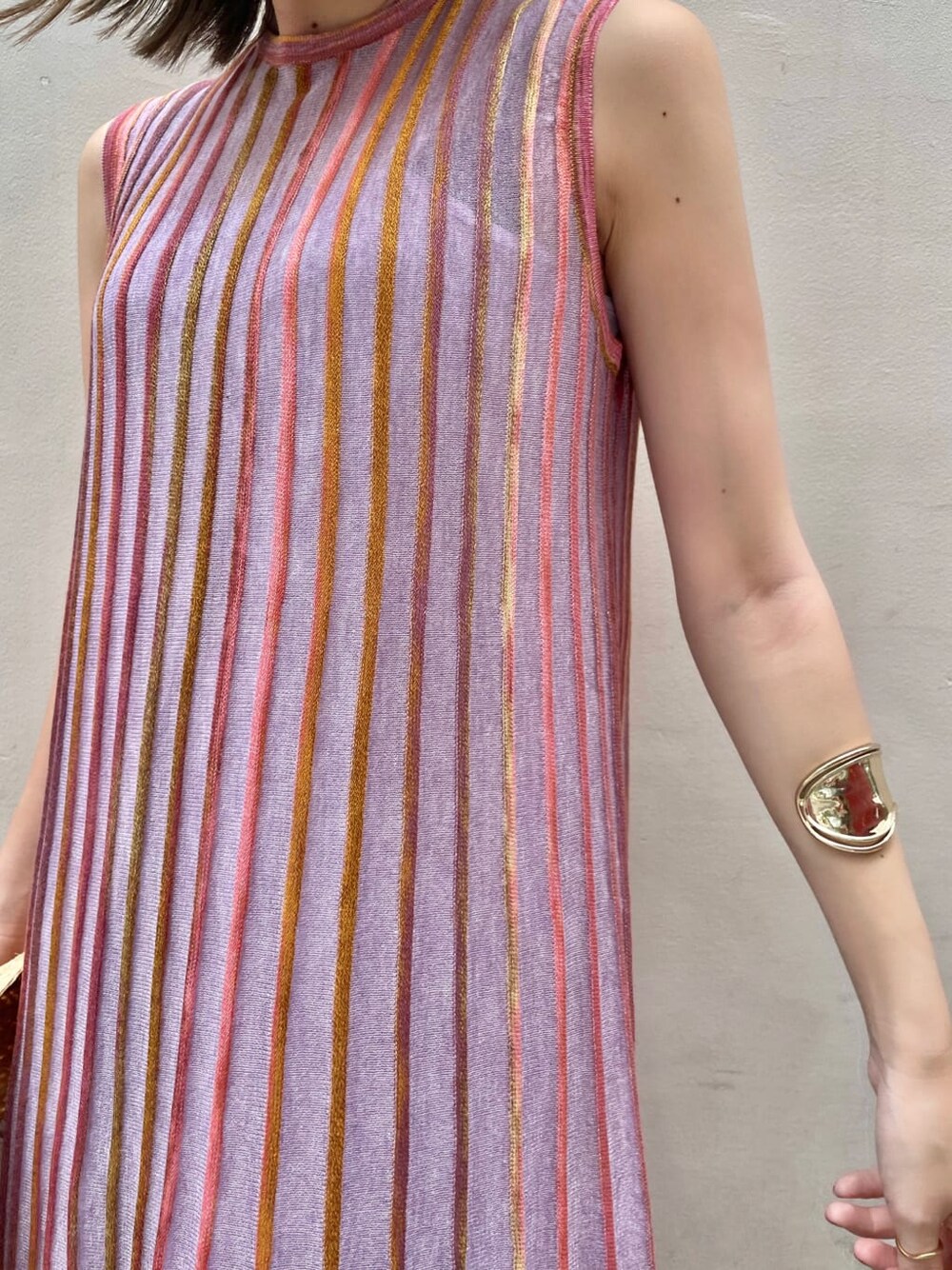 パープル系のワンピース、ベージュ系のハットを着用したレディースの夏コーディネートの4枚目の写真