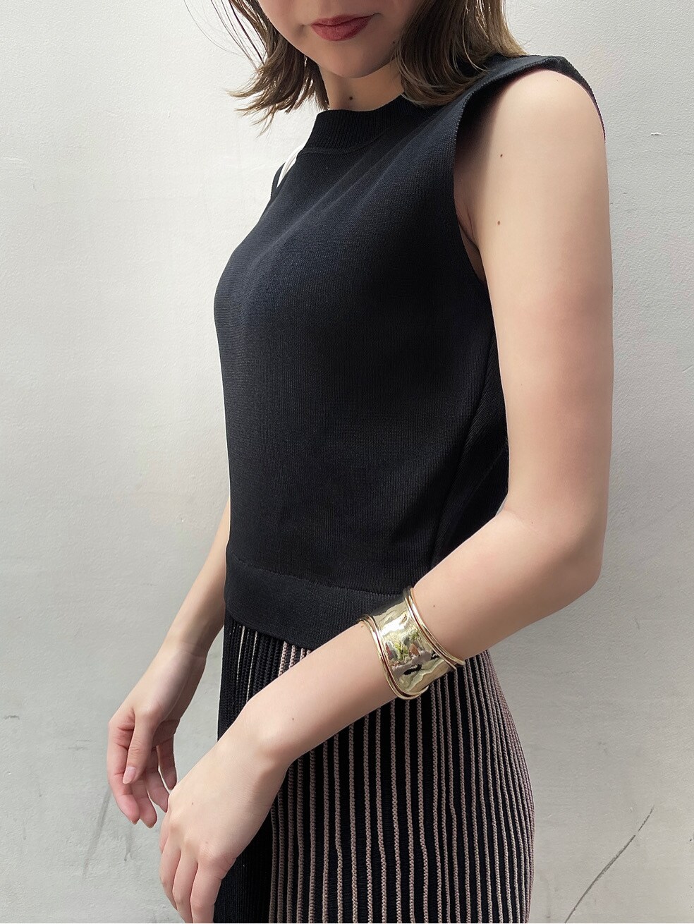 ホワイト系のショルダーバッグ、ブラック系のワンピース、ブラック系のサンダルを着用したレディースの春コーディネートの5枚目の写真