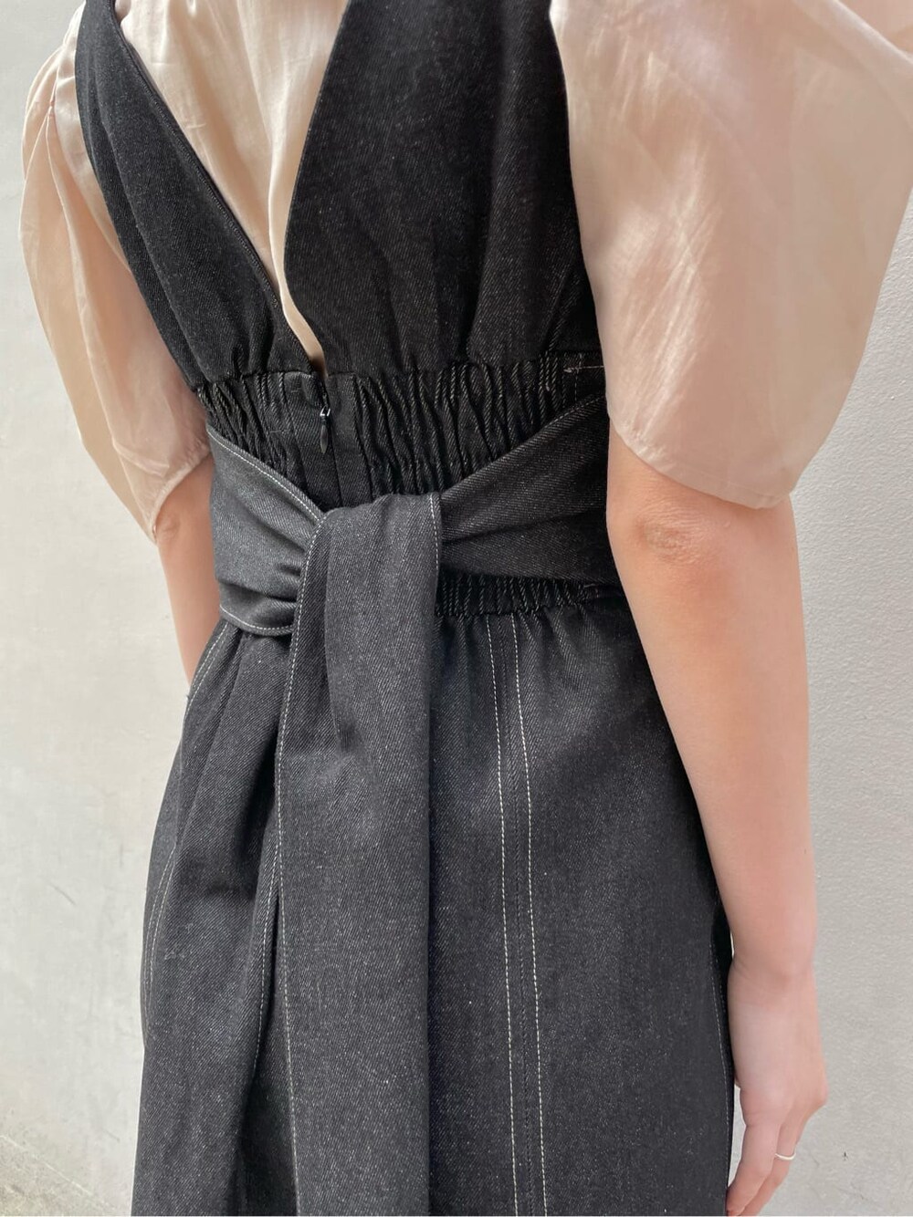 ブラック系のワンピース、ブラック系のブルゾン、ブラウン系のパンプスを着用したレディースの春コーディネートの6枚目の写真