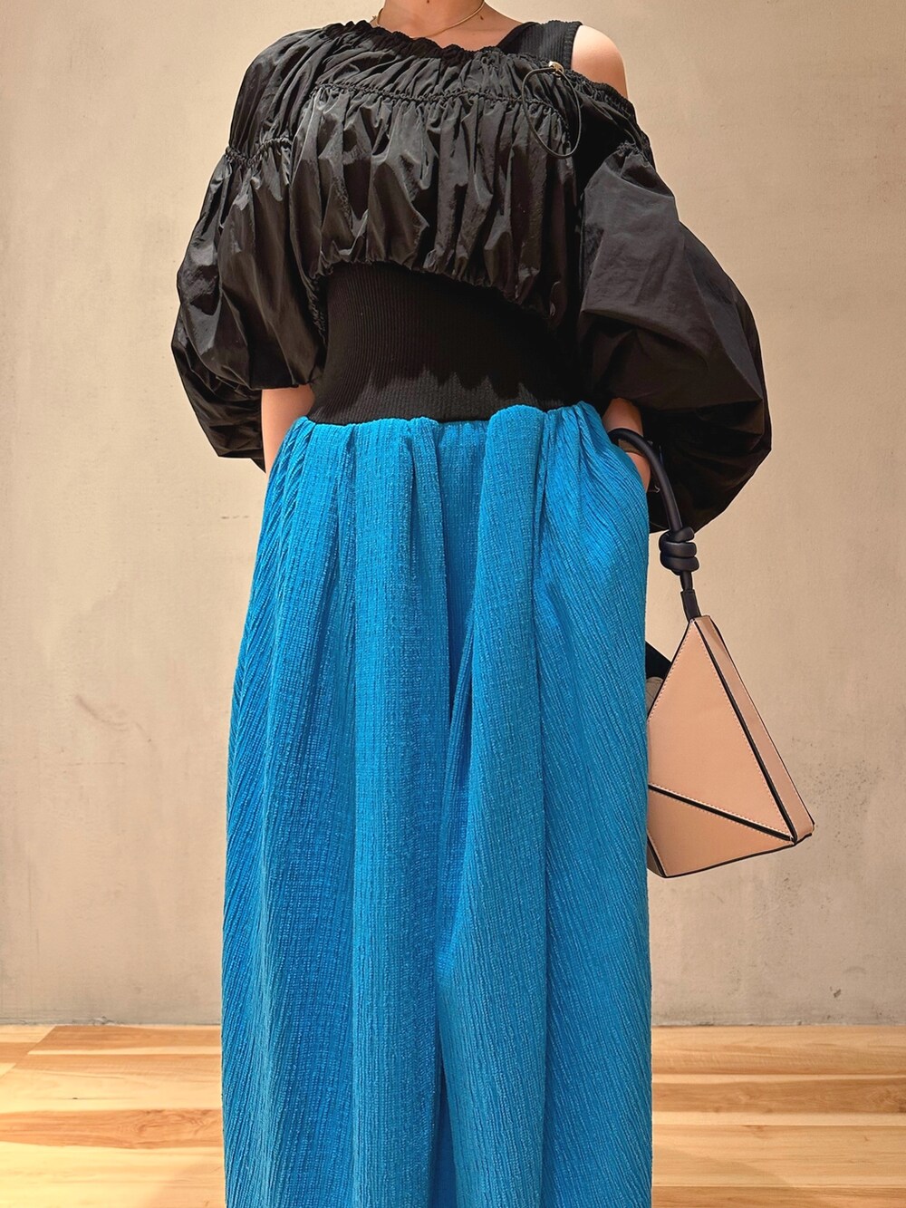 ベージュ系のハンドバッグ、ブルー系のワンピース、ホワイト系のスニーカーを着用したレディースの冬コーディネートの2枚目の写真