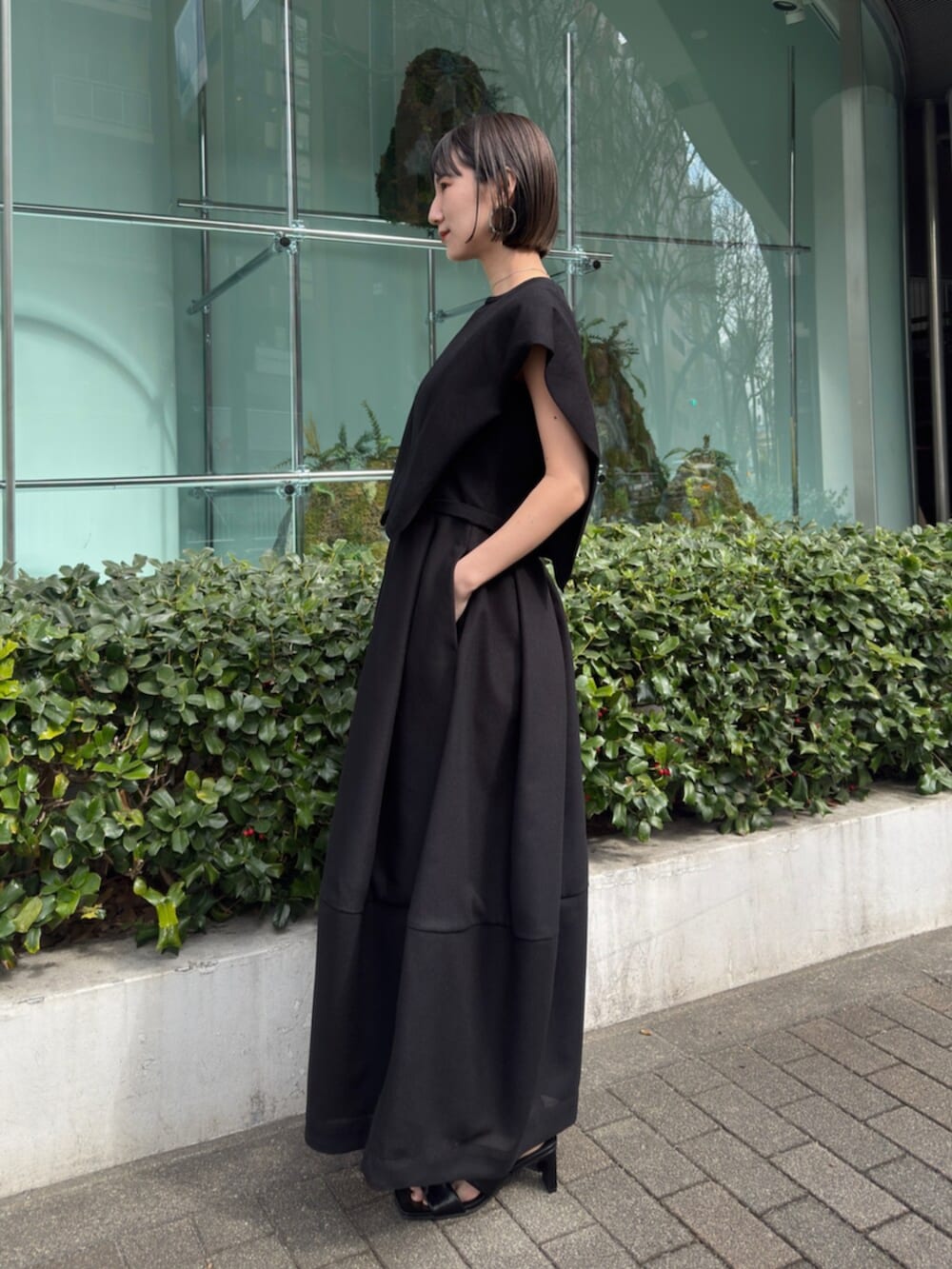 ブラック系のワンピースを着用したレディースの春コーディネートの2枚目の写真