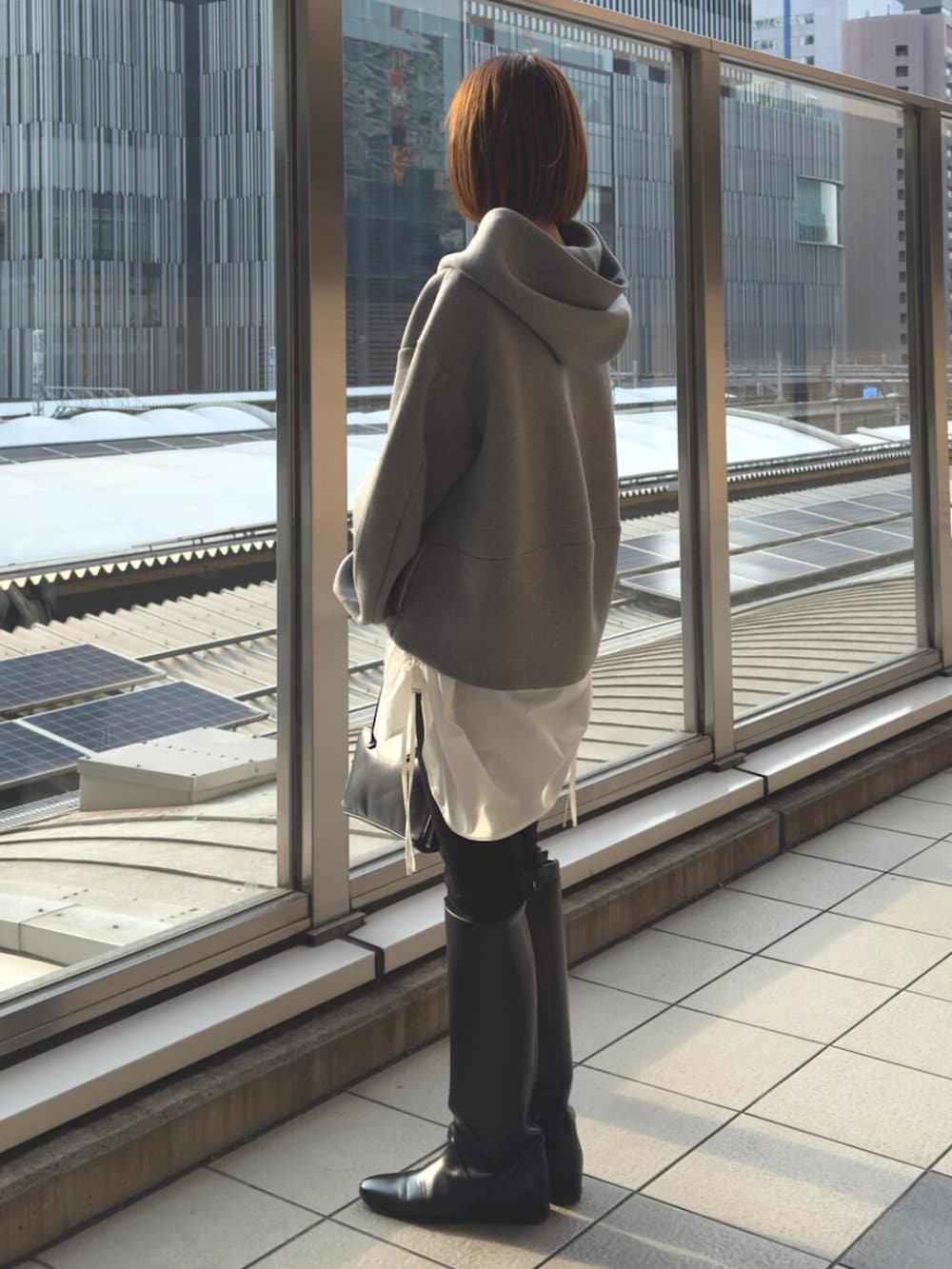 グレー系のパーカー、ブラック系のボストンバッグを着用したレディースの冬コーディネートの4枚目の写真