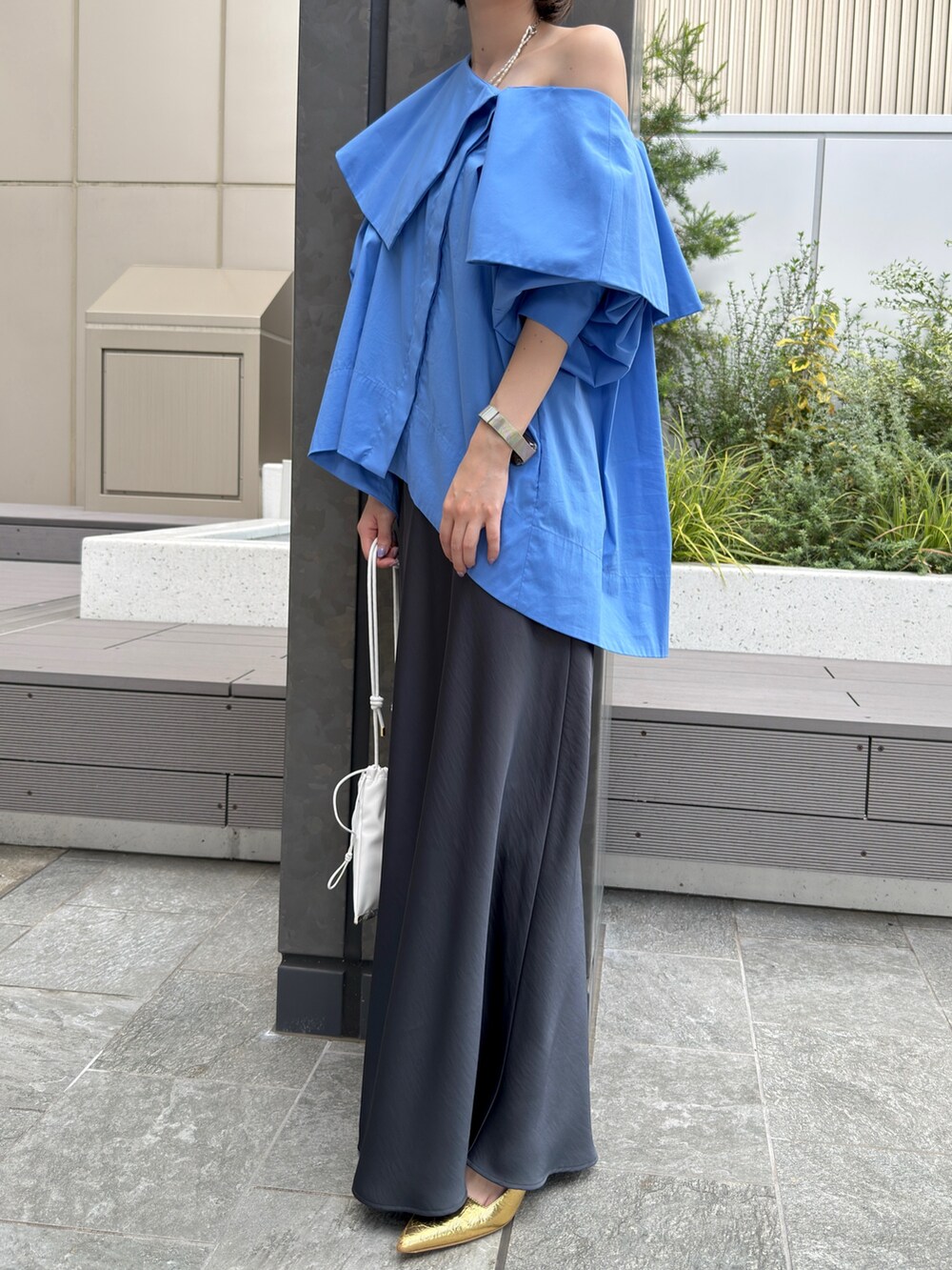 ブルー系のシャツ/ブラウス、グレー系のスカート、ゴールド系のネックレスを着用したレディースの夏コーディネートの4枚目の写真