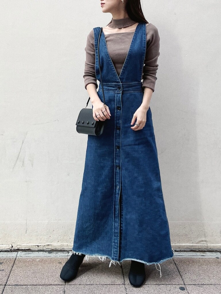 ブルー系のスカート、ブラック系のハンドバッグ、ブラウン系のニット/セーターを着用したレディースの冬コーディネートの3枚目の写真