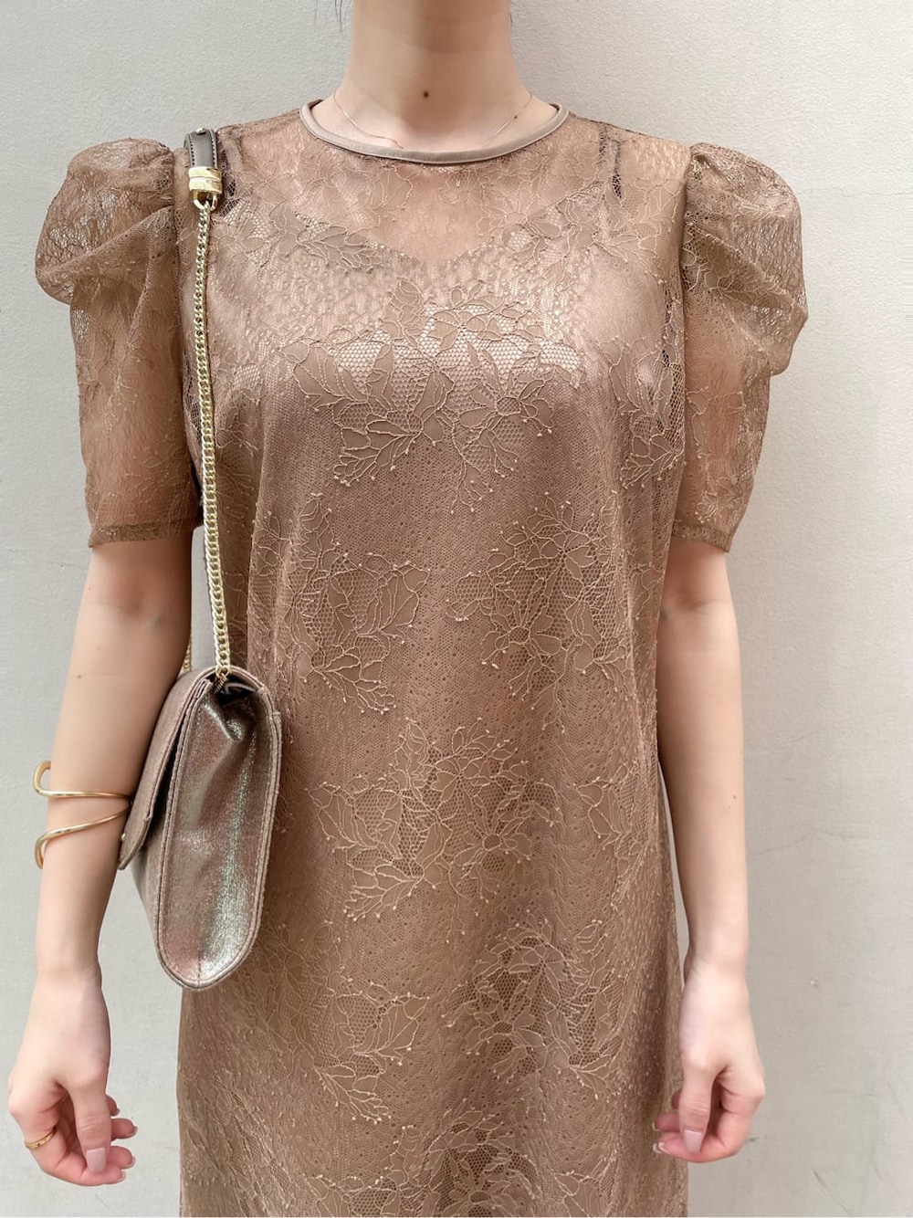 ベージュ系のパンプス、ゴールド系のクラッチバッグ、ベージュ系のドレスを着用したレディースの春コーディネートの6枚目の写真