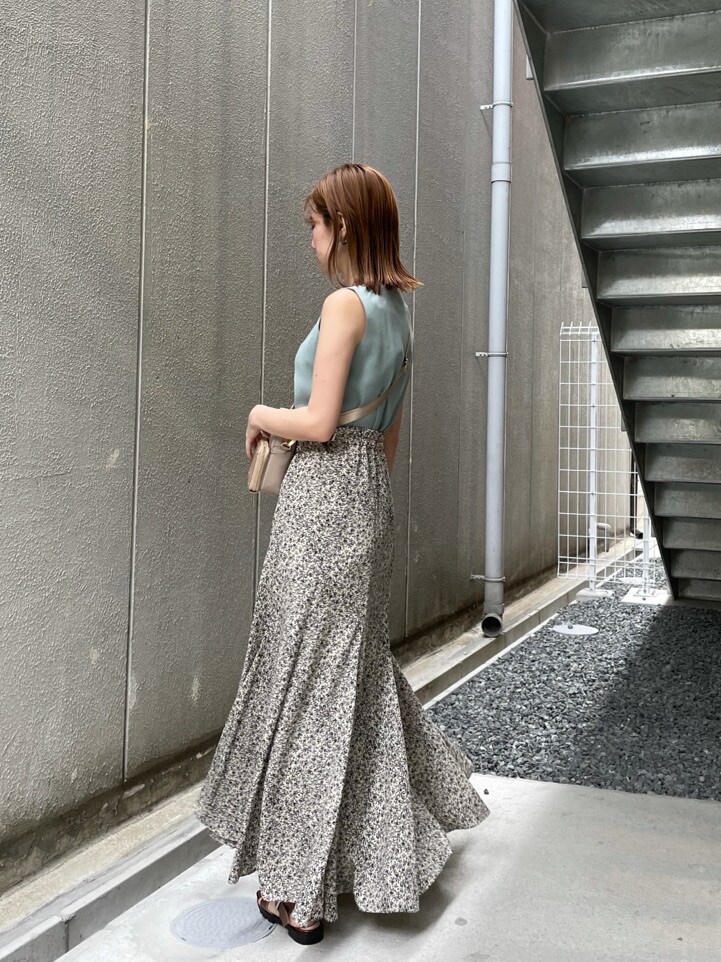 ブラウン系のサンダル、グリーン系のニット/セーター、ホワイト系のスカートを着用したレディースの夏コーディネートの5枚目の写真