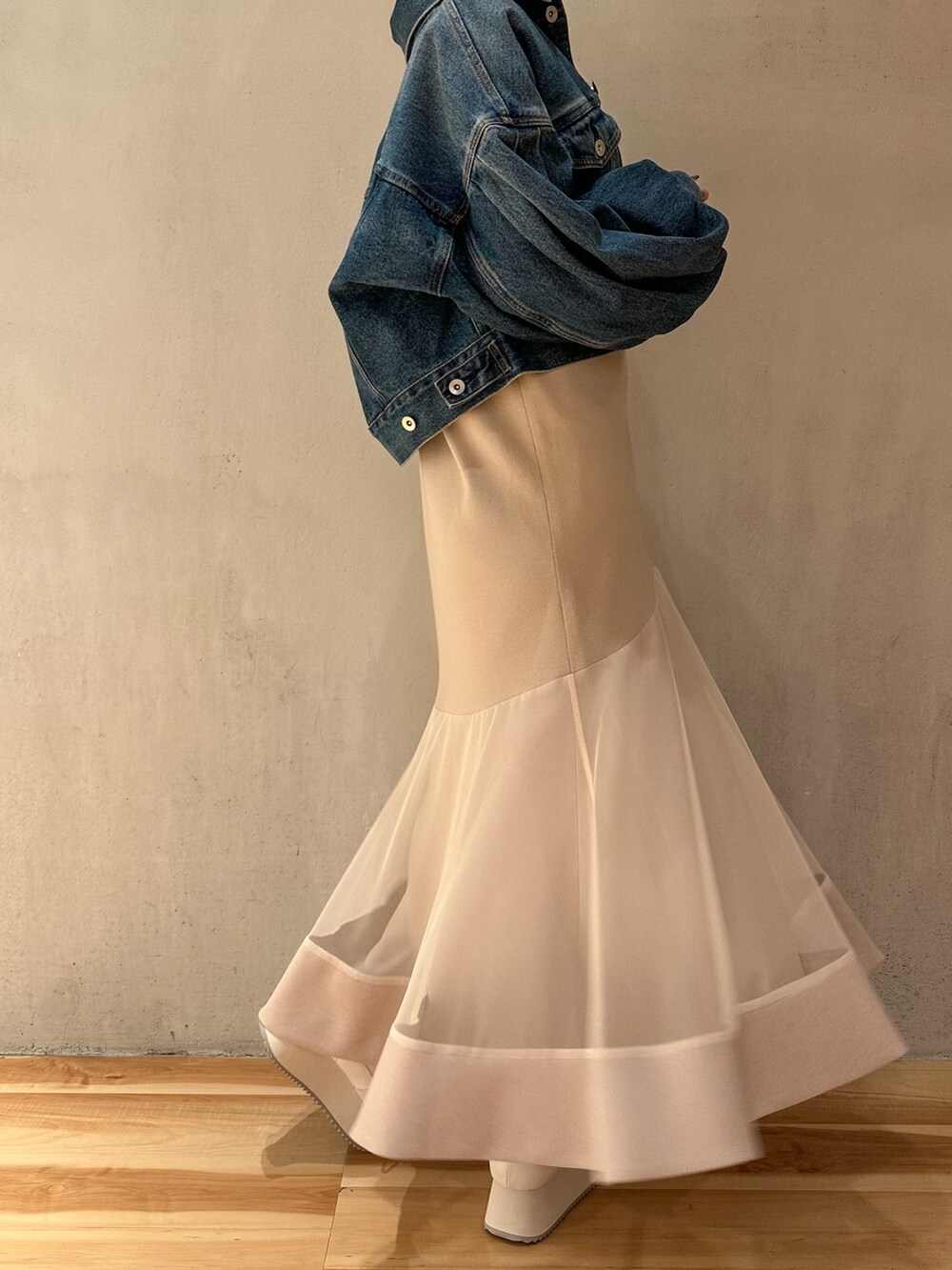 ブルー系のデニムジャケット、ベージュ系のワンピース、ホワイト系のスニーカーを着用したレディースの春コーディネートの5枚目の写真