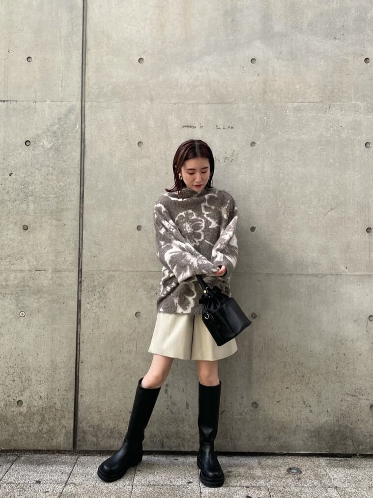 ブラック系のブーツ、ホワイト系のその他パンツ、ブラック系のハンドバッグを着用したレディースの秋コーディネートの2枚目の写真