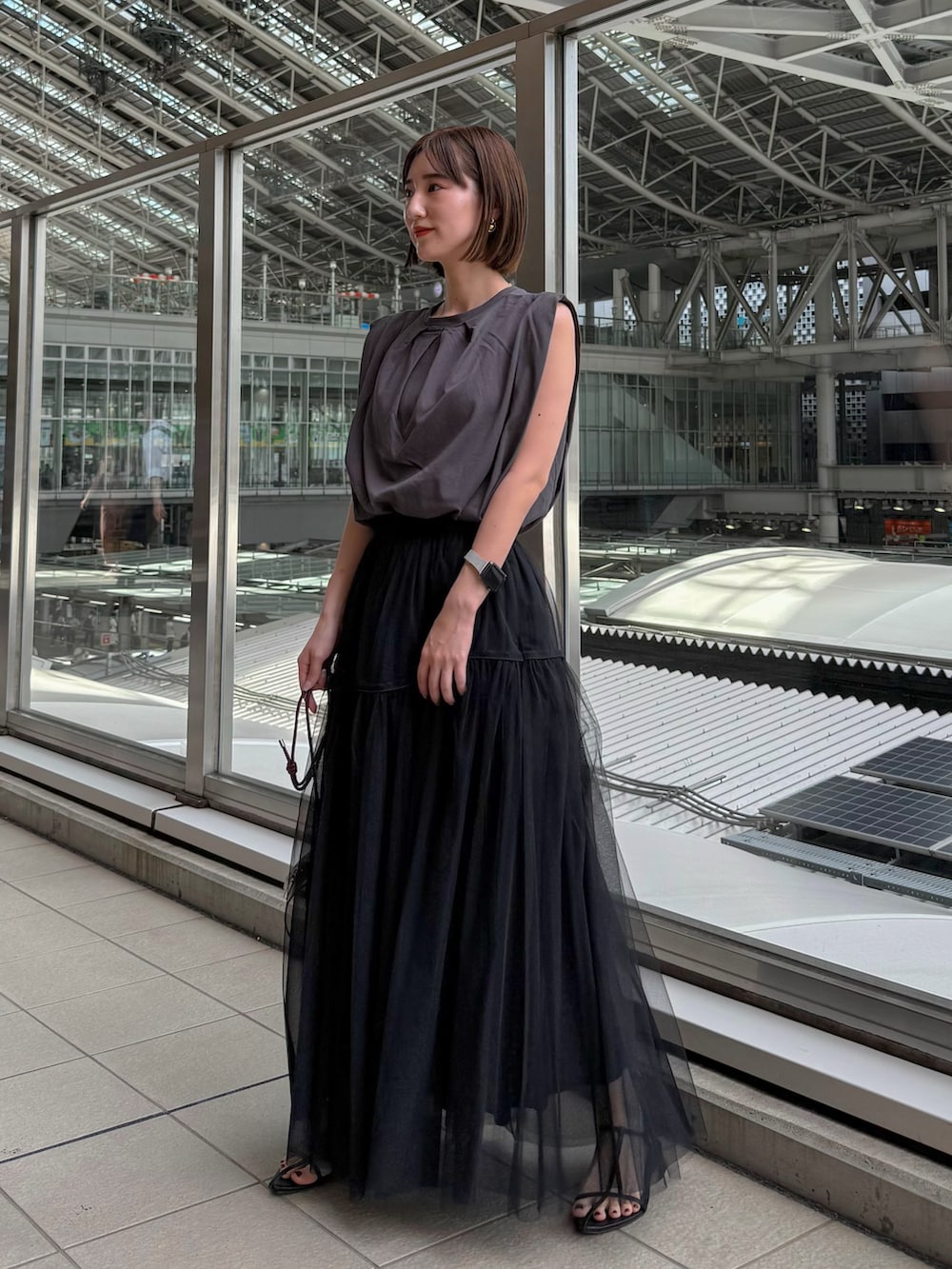 グレー系のTシャツ/カットソー、ブラック系のスカート、レッド系のショルダーバッグを着用したレディースの夏コーディネートの2枚目の写真