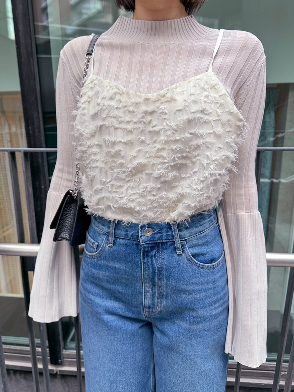 ブルー系のデニムパンツ、ホワイト系のキャミソール、ホワイト系のニット/セーターを着用したレディースの冬コーディネートの2枚目の写真