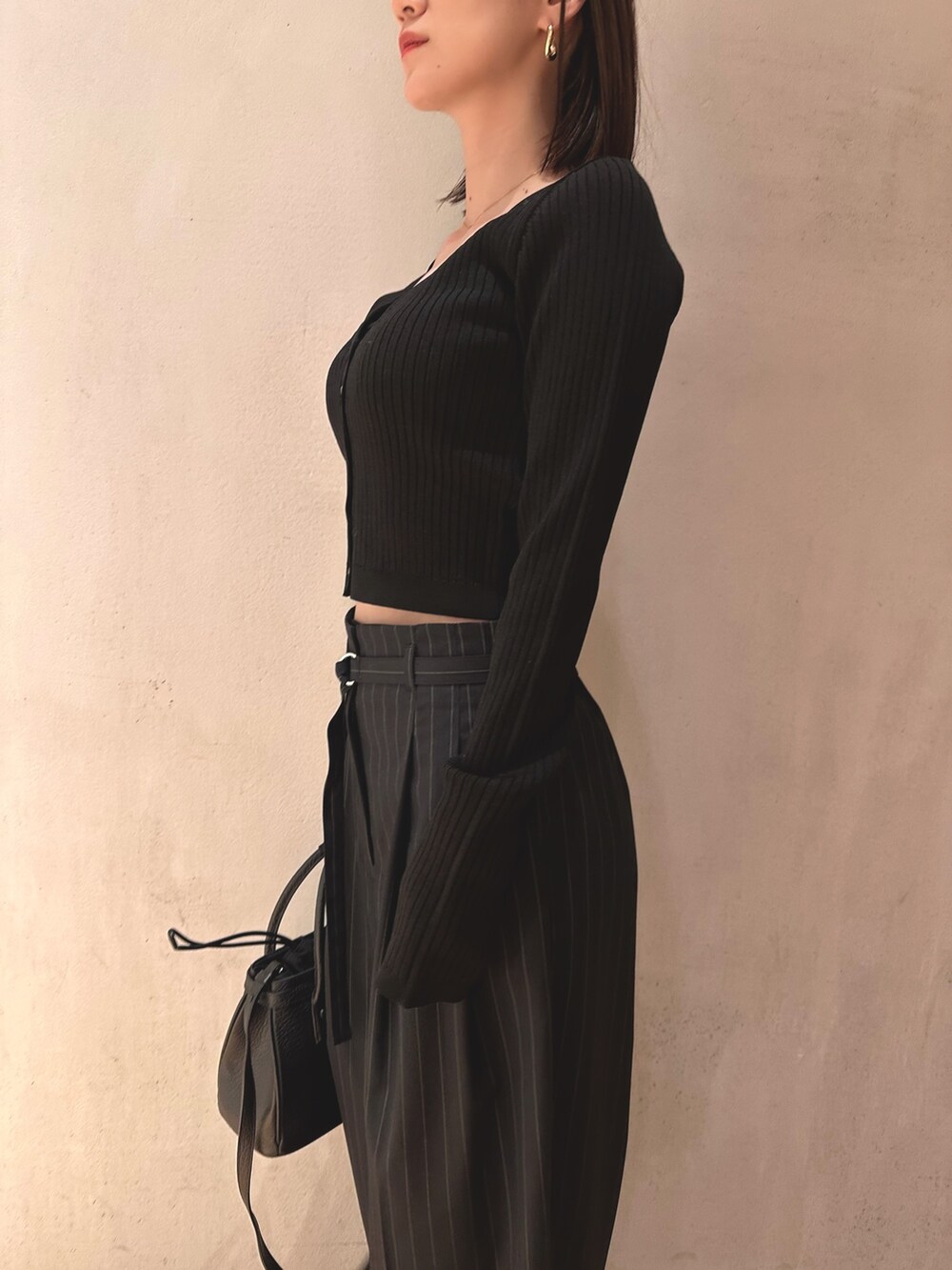 ブラック系のカーディガン/ボレロ、ブラック系のショルダーバッグ、ブルー系のその他パンツを着用したレディースの春コーディネートの5枚目の写真