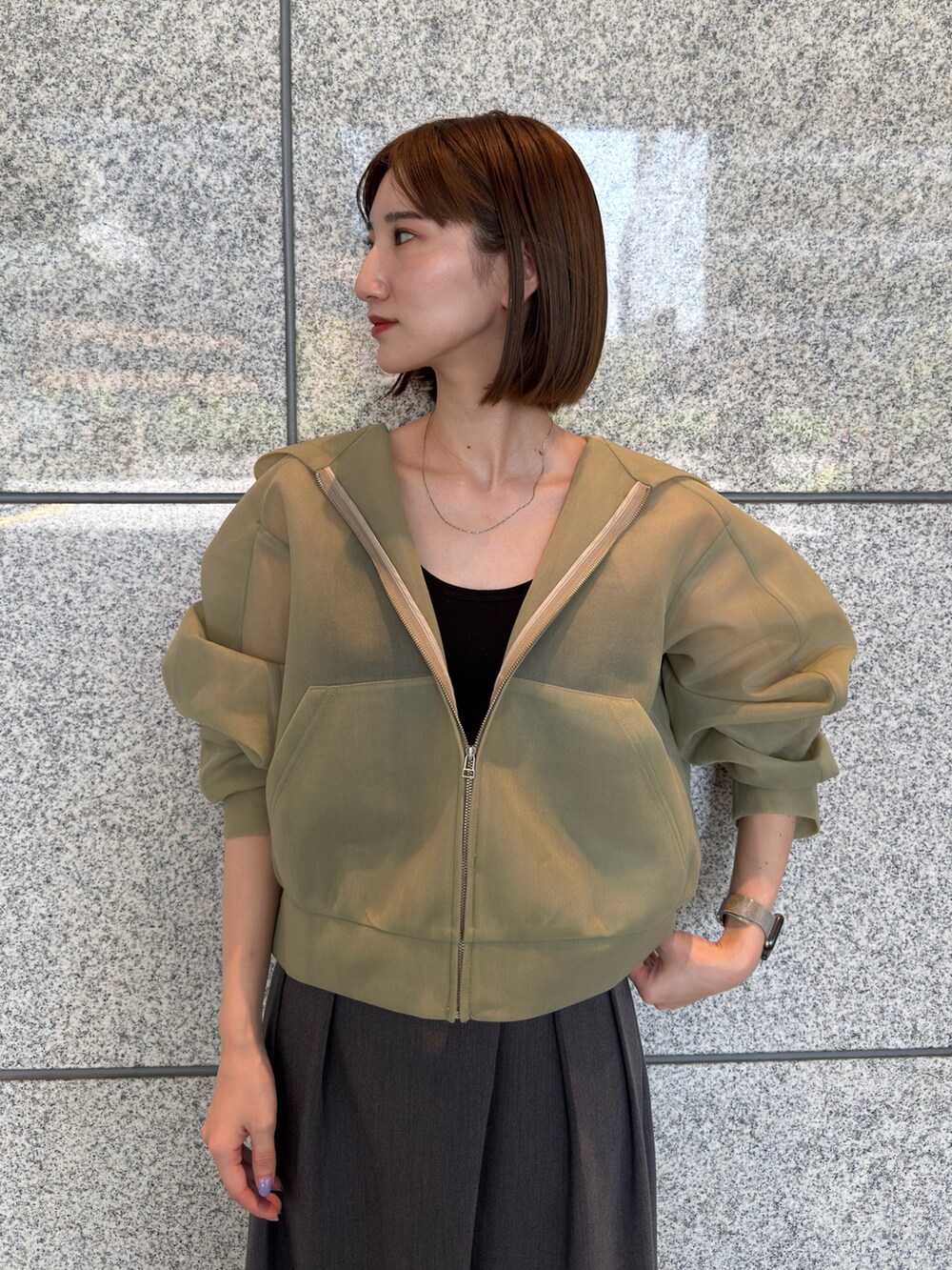 グリーン系のブルゾン、グレー系のその他パンツ、シルバー系のパンプスを着用したレディースの夏コーディネートの5枚目の写真