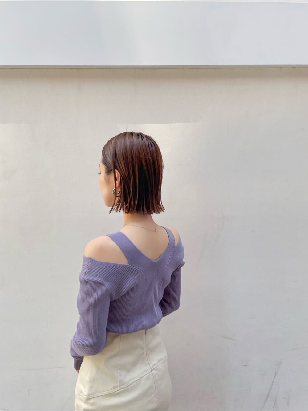 ブラウン系のパンプス、ベージュ系のスカート、パープル系のニット/セーターを着用したレディースの夏コーディネートの5枚目の写真