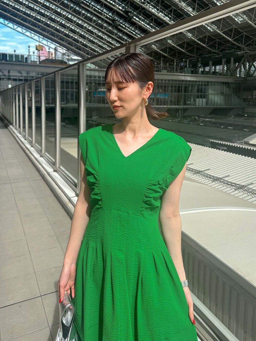 グリーン系のワンピース、ベージュ系のカーディガン/ボレロ、その他のサンダルを着用したレディースの春コーディネートの2枚目の写真