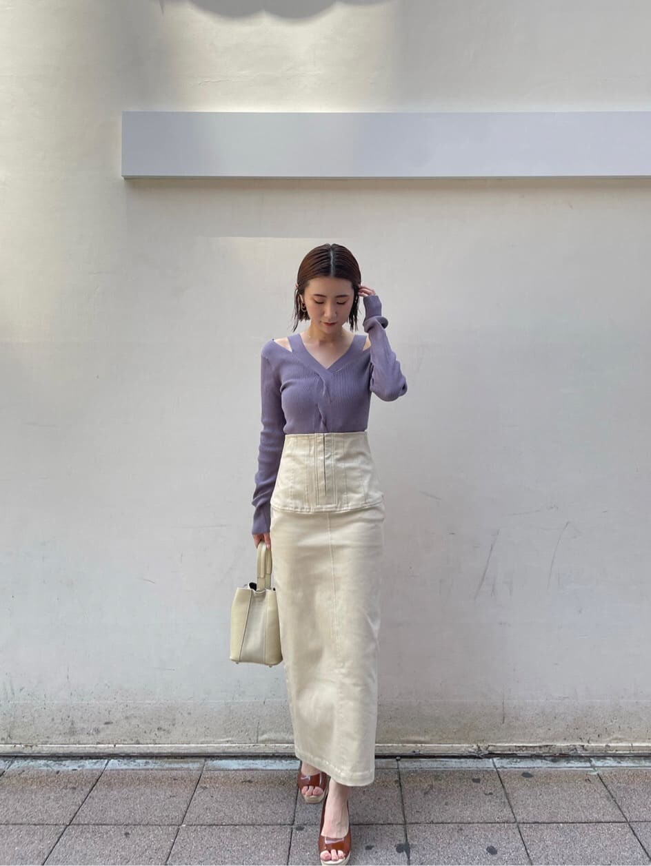 ブラウン系のパンプス、ベージュ系のスカート、パープル系のニット/セーターを着用したレディースの夏コーディネートの6枚目の写真