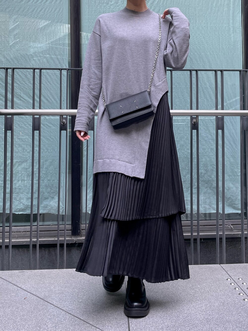 グレー系のワンピース、ブラック系のダウンジャケット/コート、ブラック系の財布を着用したレディースの冬コーディネートの4枚目の写真