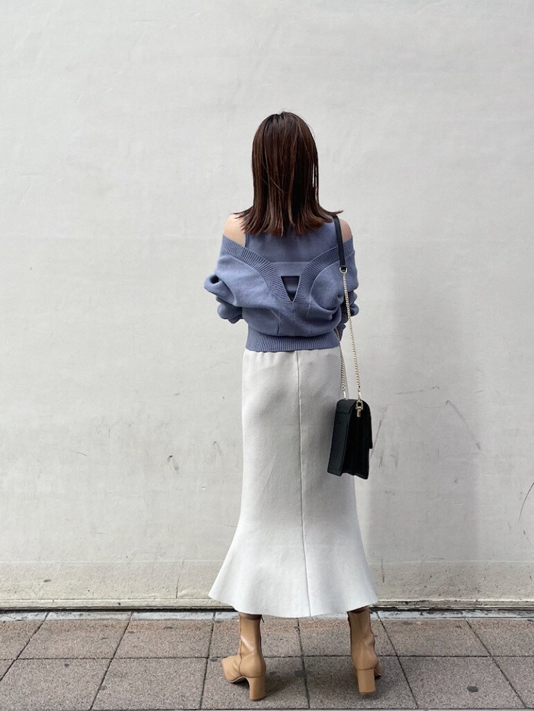 グレー系のスカート、ブルー系のニット/セーターを着用したレディースの冬コーディネートの6枚目の写真