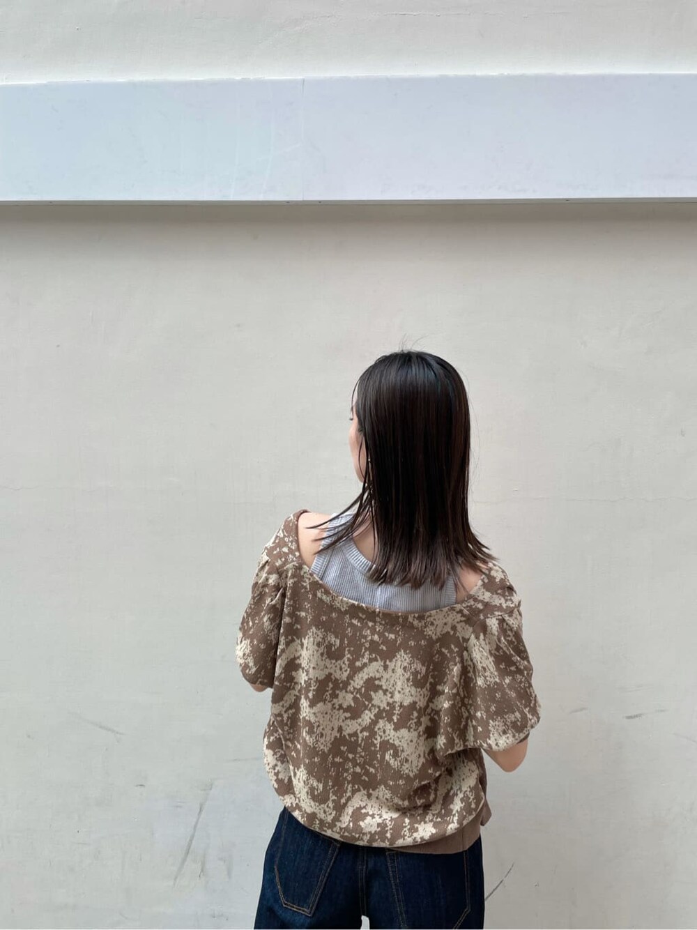 ブルー系のデニムパンツ、オレンジ系のスリッポン、ブラウン系のニット/セーターを着用したレディースの秋コーディネートの5枚目の写真