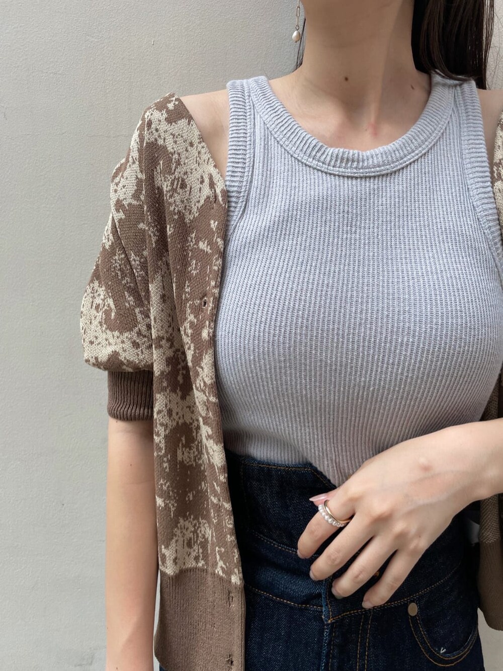 ブルー系のデニムパンツ、オレンジ系のスリッポン、ブラウン系のニット/セーターを着用したレディースの秋コーディネートの3枚目の写真